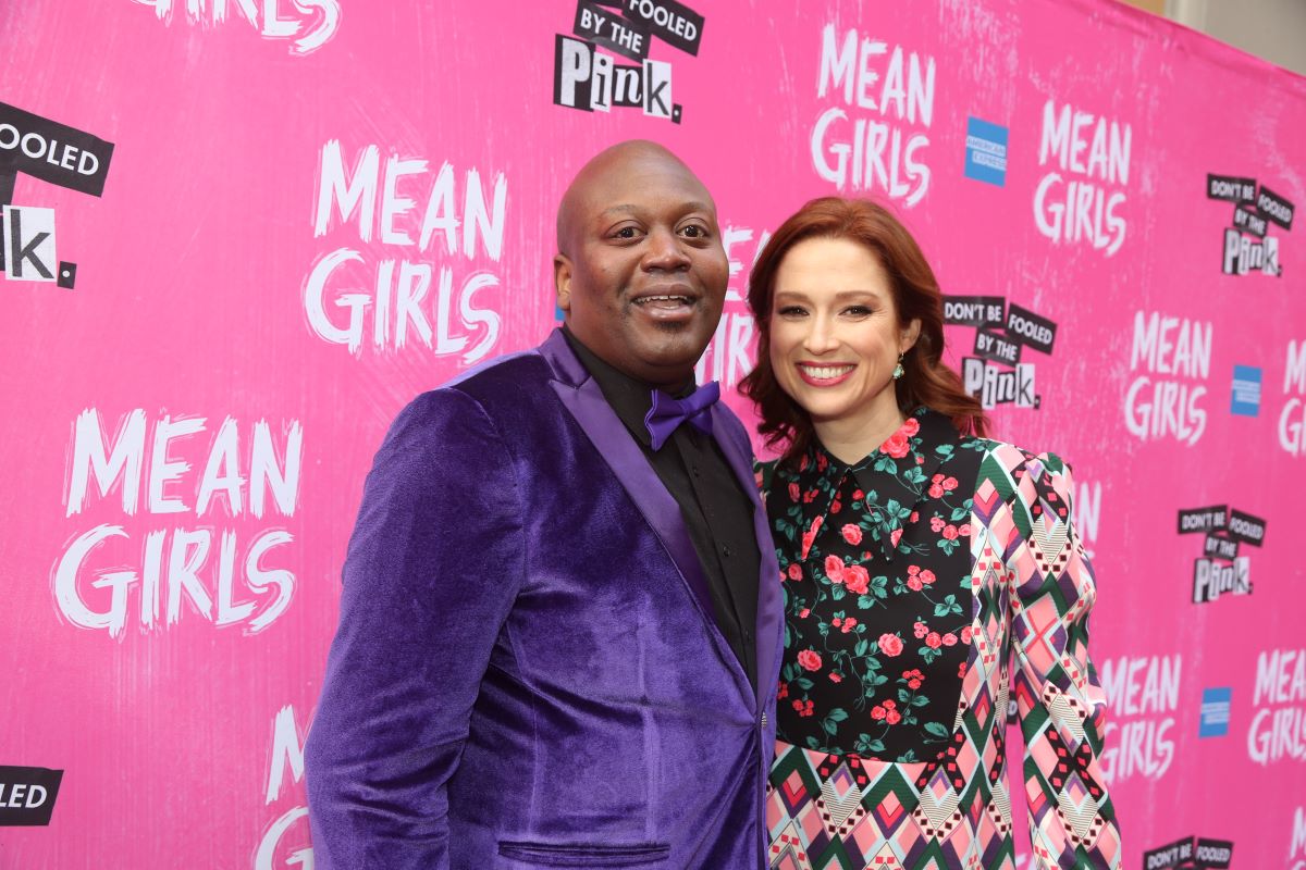 'Unbreakable Kimmie Schmidt' star Tituss Burgess in a purple suit with black shirt and Ellie Kemper in a flower suit