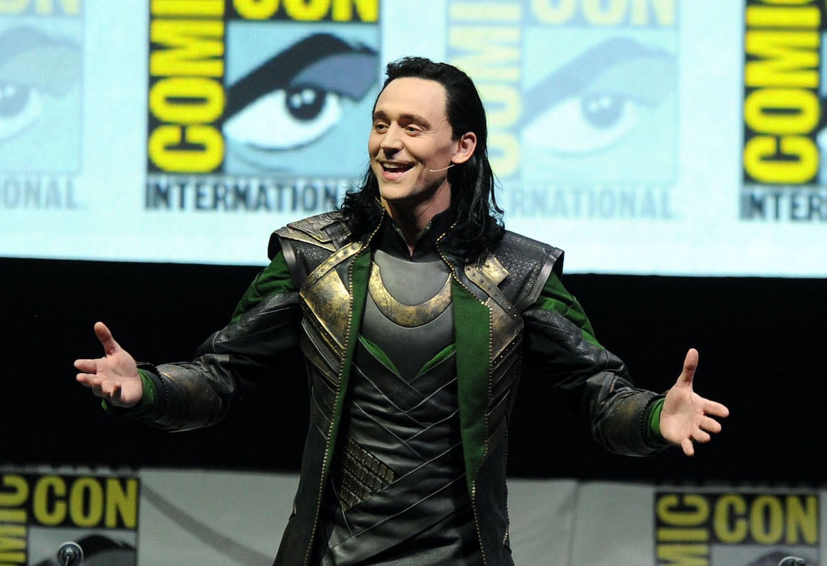 Tom Hiddleston dressed as Loki in a black, green, and gold suit and long black hair at Comic-Con 2013