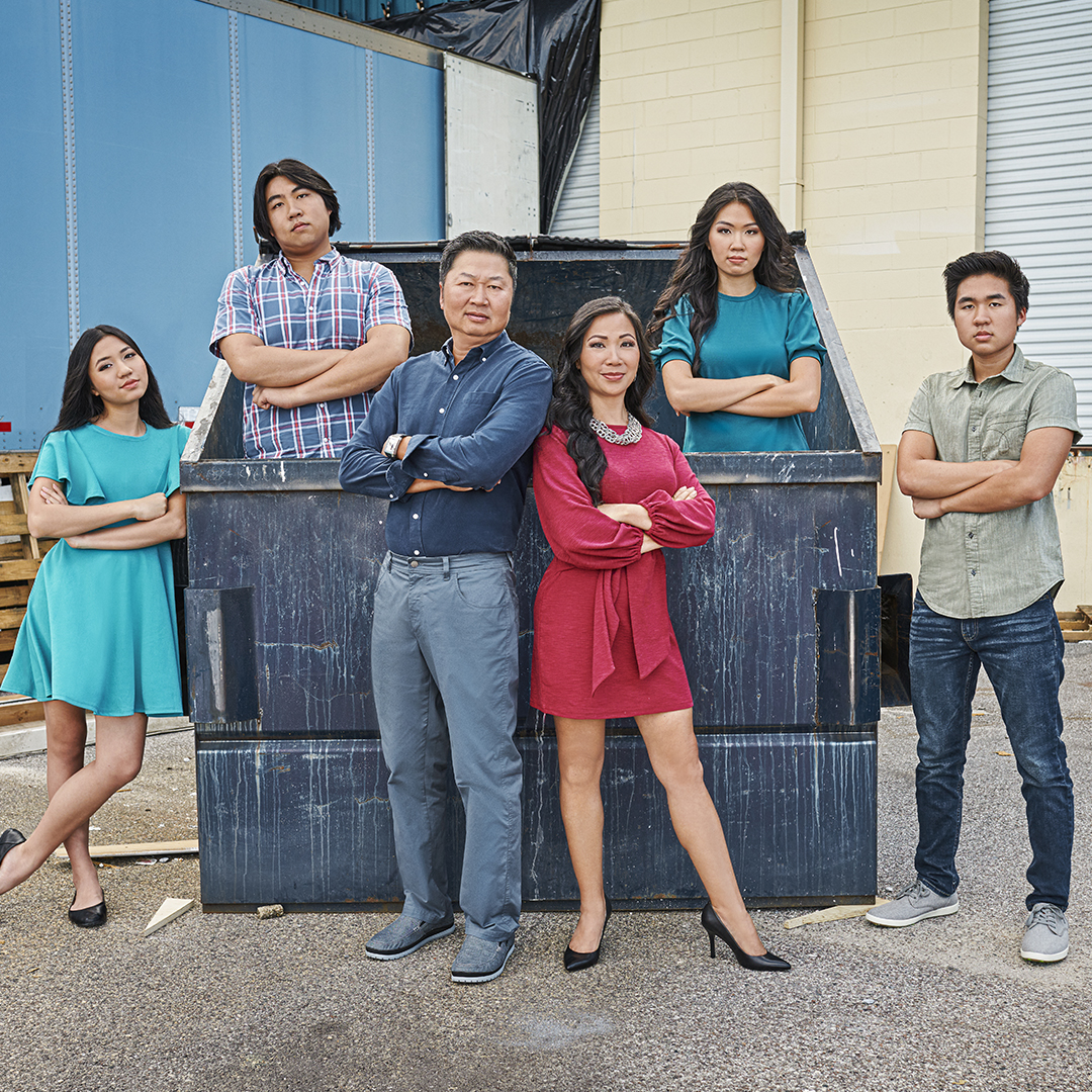 The Tran family from So Freakin Cheap standing in front of dumpster