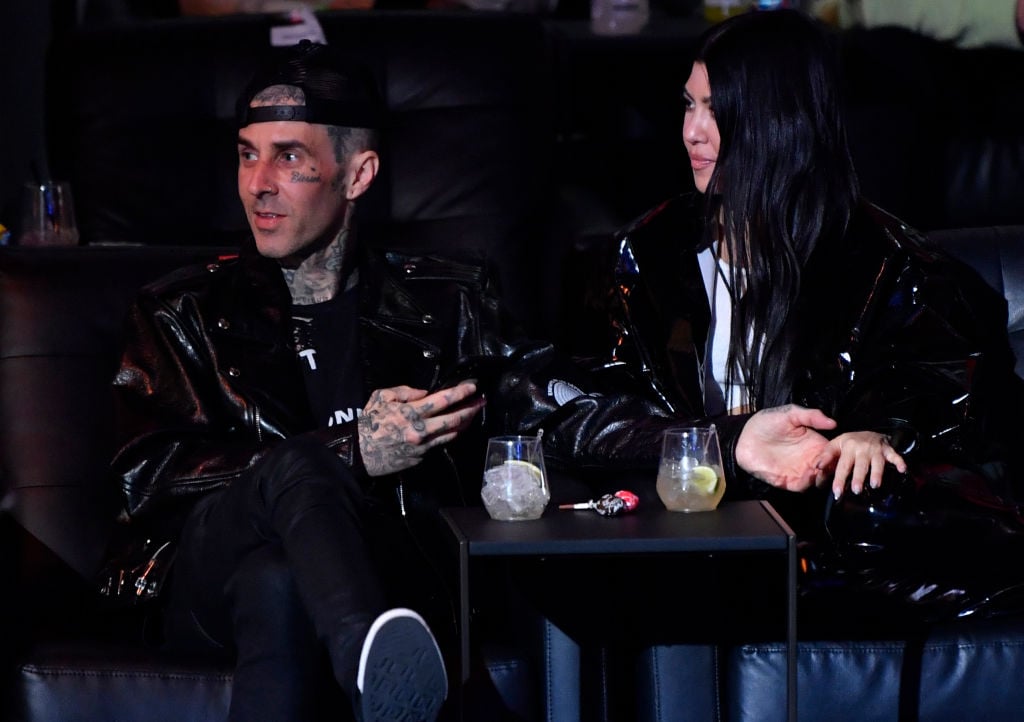 Travis Barker and Kourtney Kardashian sit at a table during the UFC 260 event in Las Vegas.