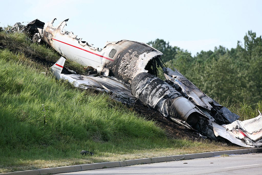 Wreckage from the burned up plane lies in the grass.