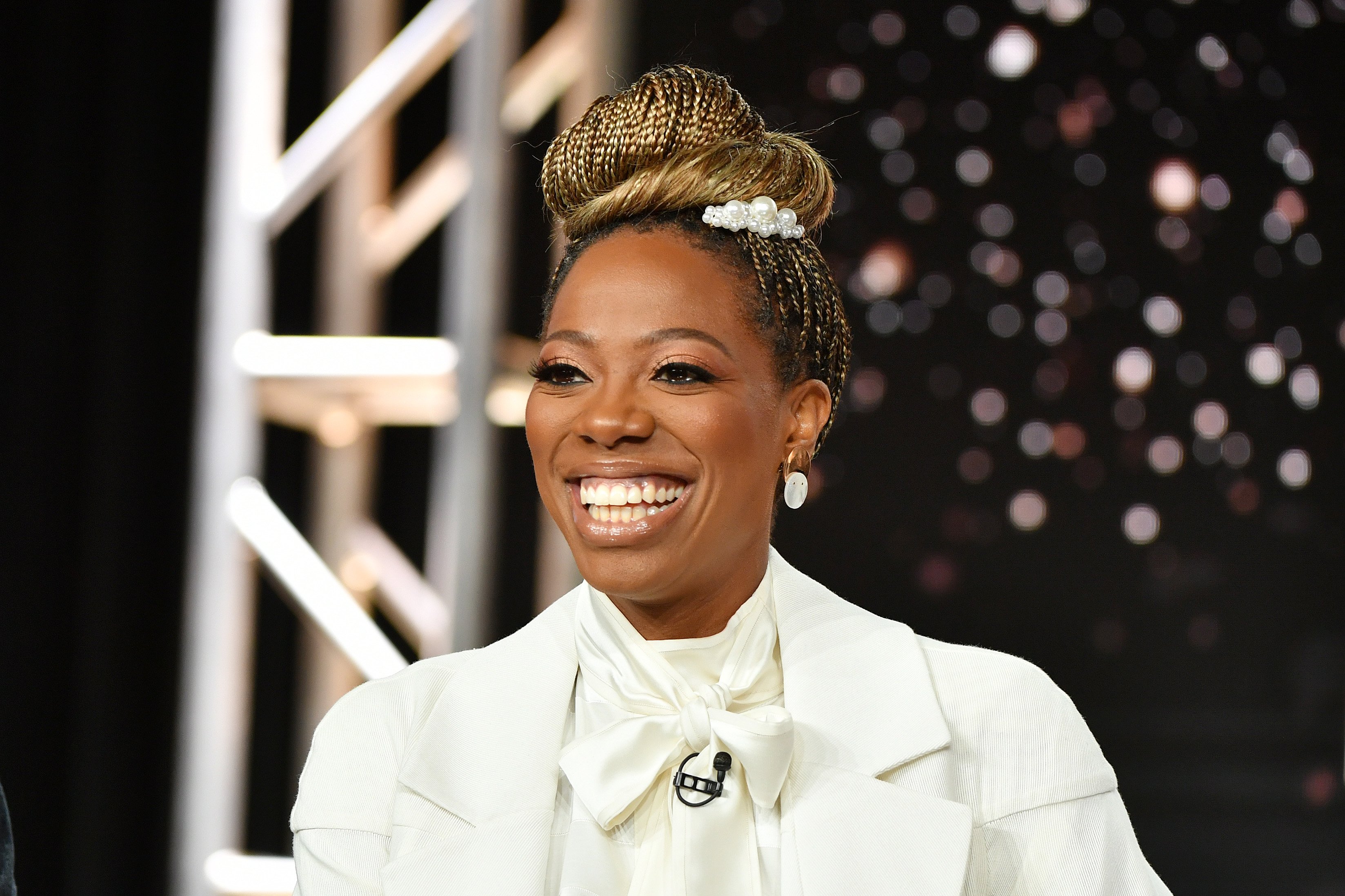 Actor Yvonne Orji from 'Insecure' smiling in a white top and braided bun for an HBO event.