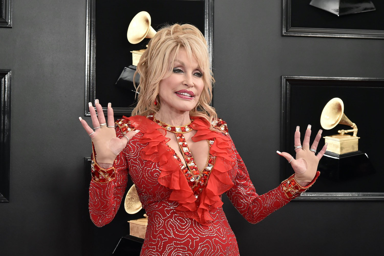 Dolly Parton wears a red low cut dress as she poses at the 61st Annual Grammy Awards at Staples Center on February 10, 2019