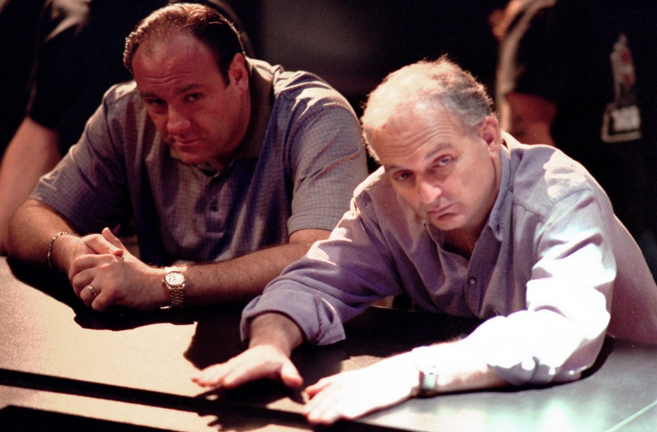 James Gandolfini and David Chase lean on a counter and look off-camera while filming 'The Sopranos.'