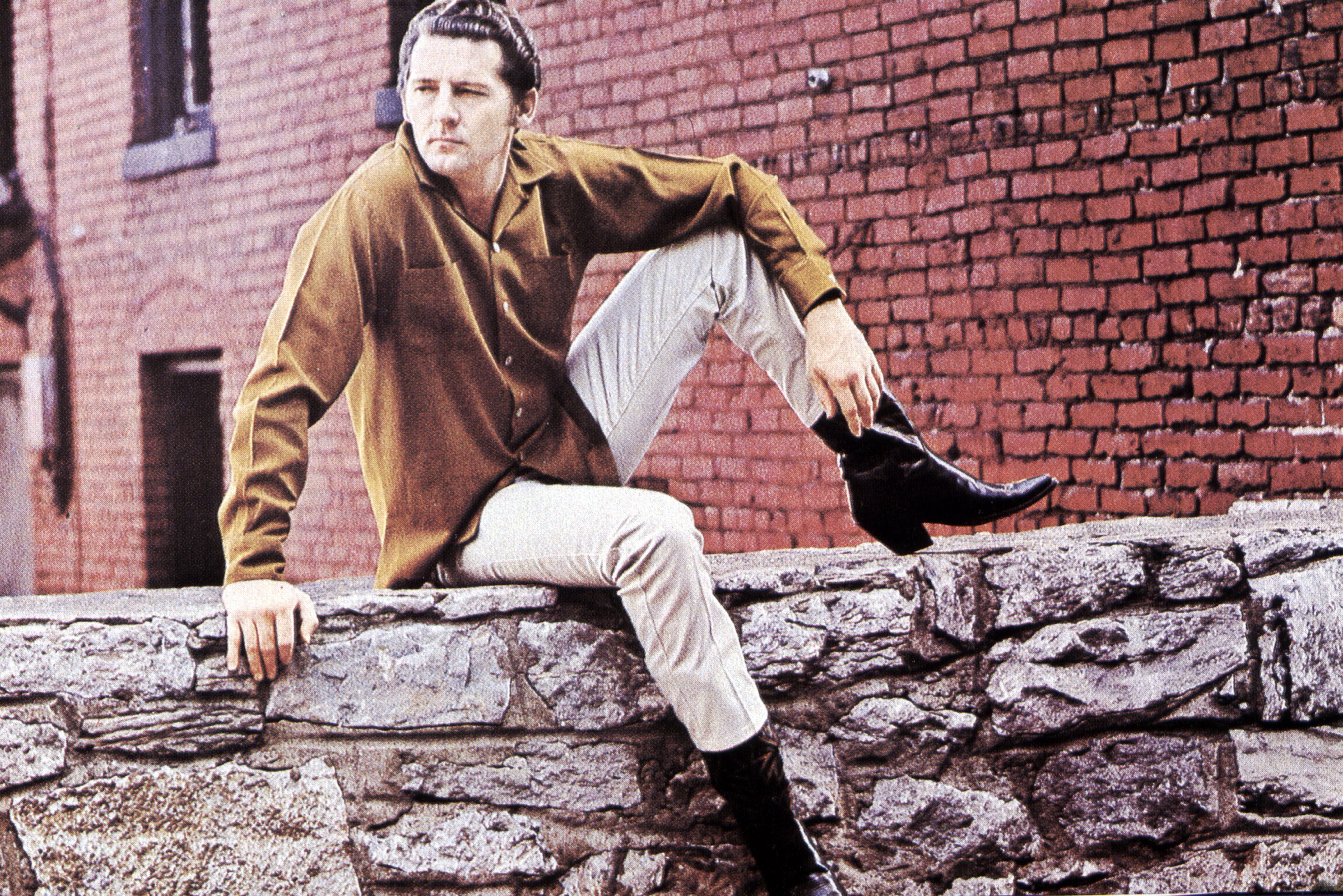 Jerry Lee Lewis sitting on a wall