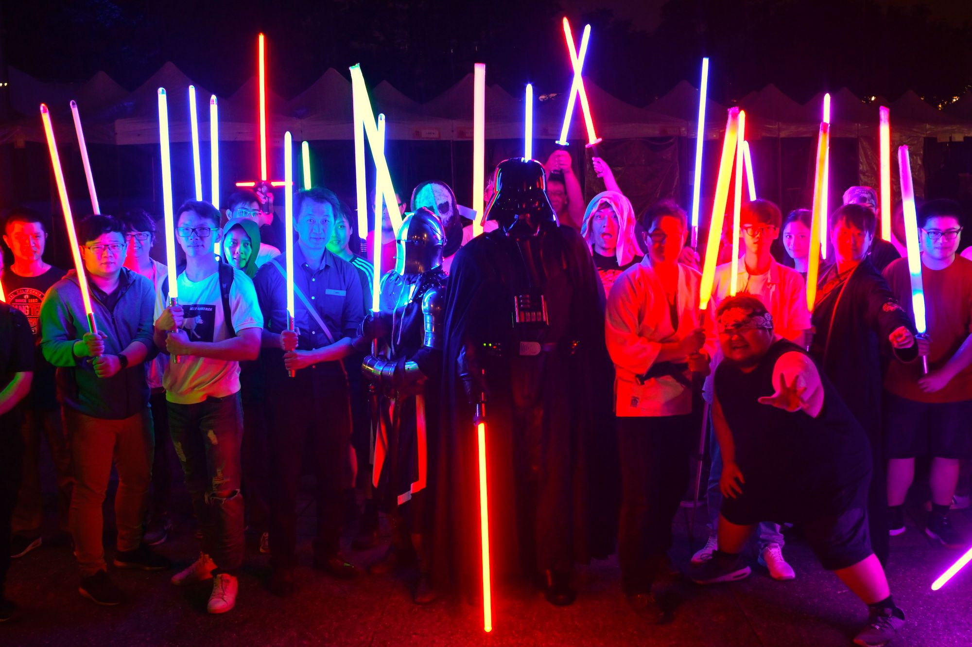 Star Wars fans with model lightsabers