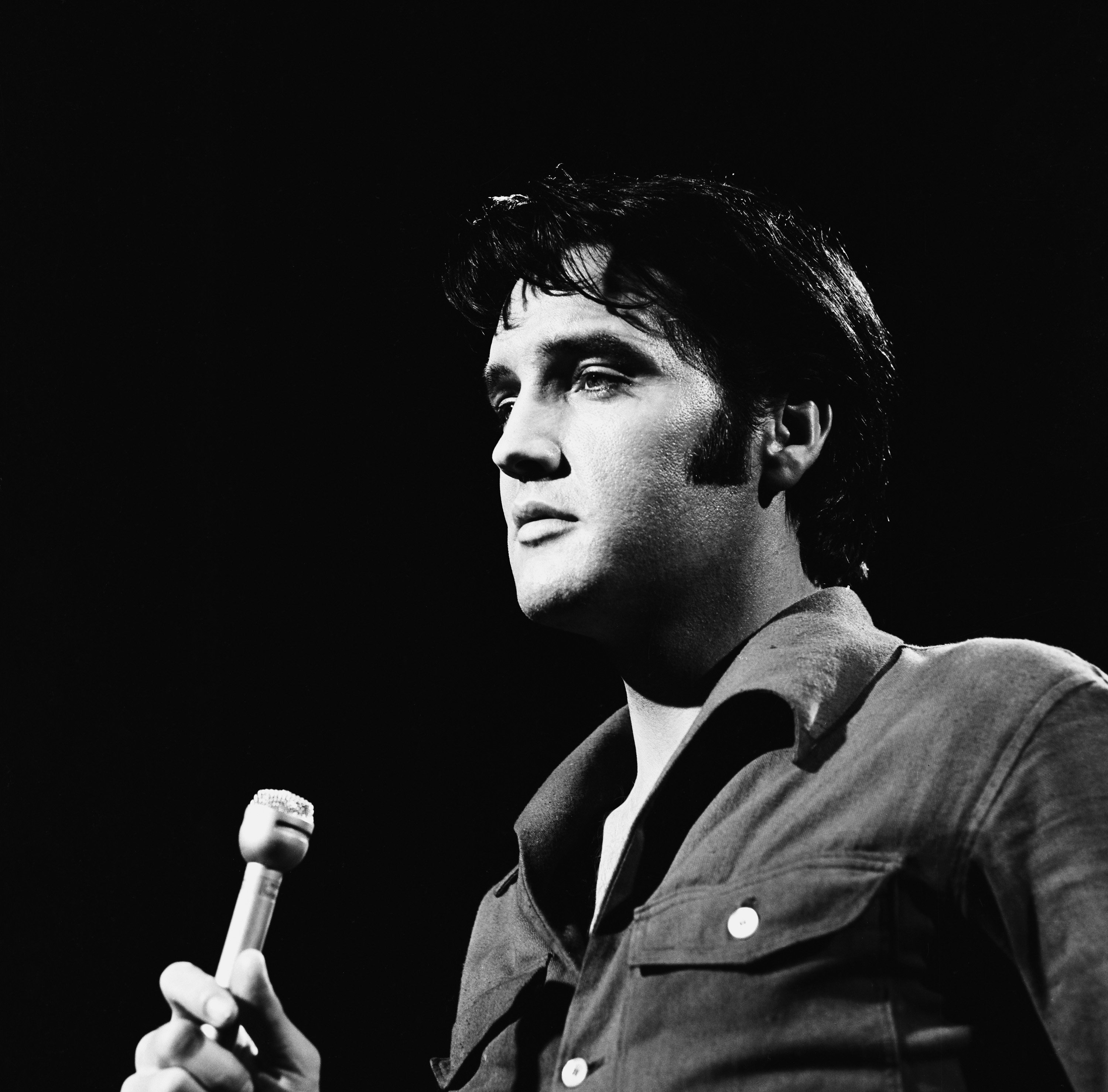 Elvis Presley performing songs into a microphone