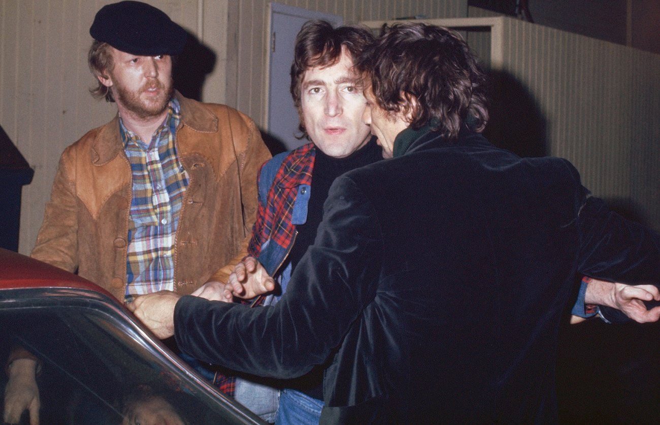Harry Nilsson and John Lennon getting kicked out of the Troubadour club in 1974. Lennon stares at the camera as an unidentified man tries to get him into a car.