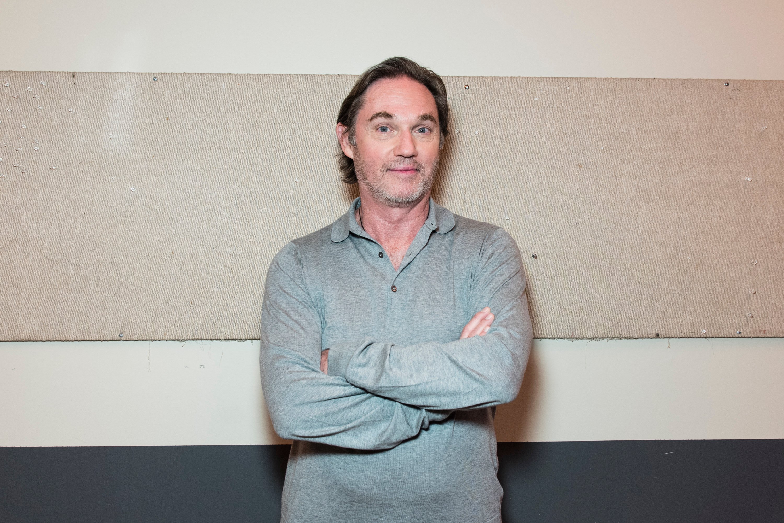 Actor Richard Thomas standing in front of a gray wall