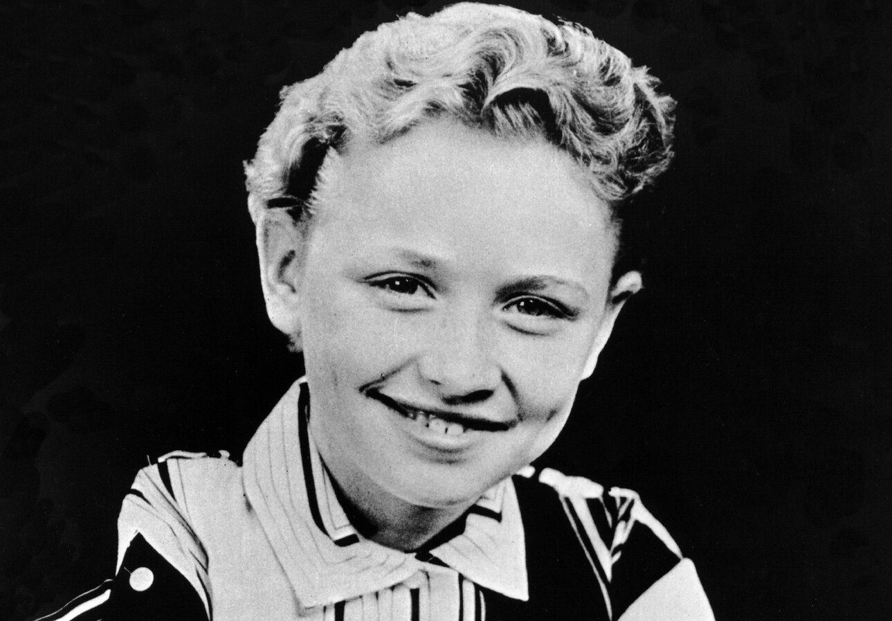Dolly Parton photographed as a child in 1955 in black and white.