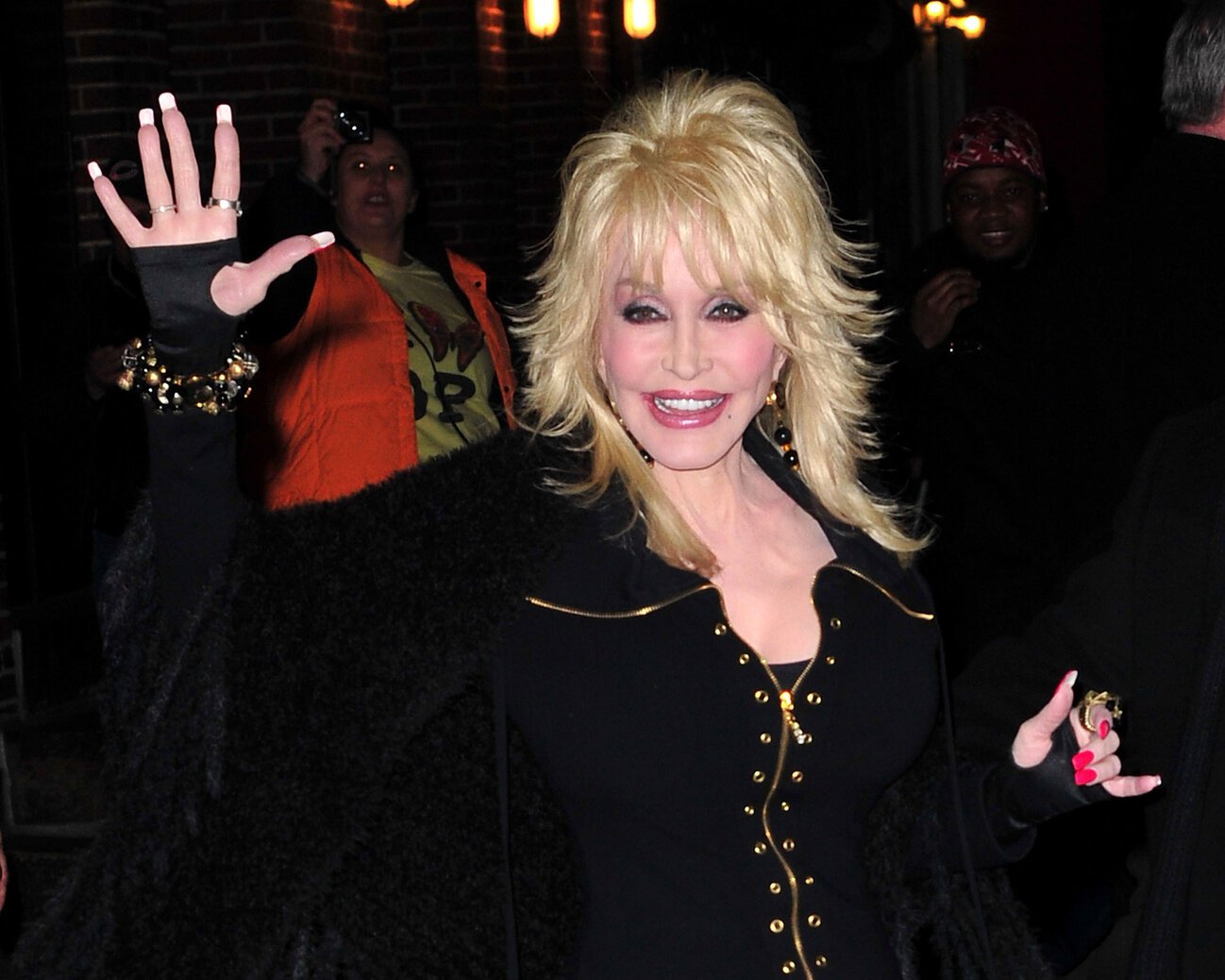 Dolly Parton visiting "Late Show with David Letterman" in 2012. She's wearing a black outfit with her signature black fingerless gloves.