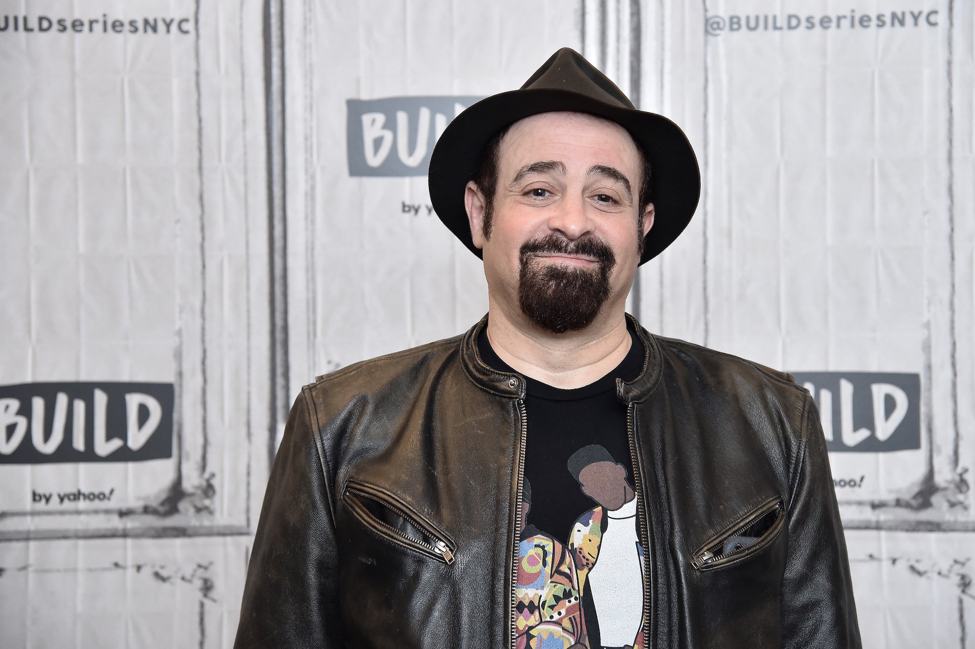 Adam Duritz wearing a hat and leather jacket