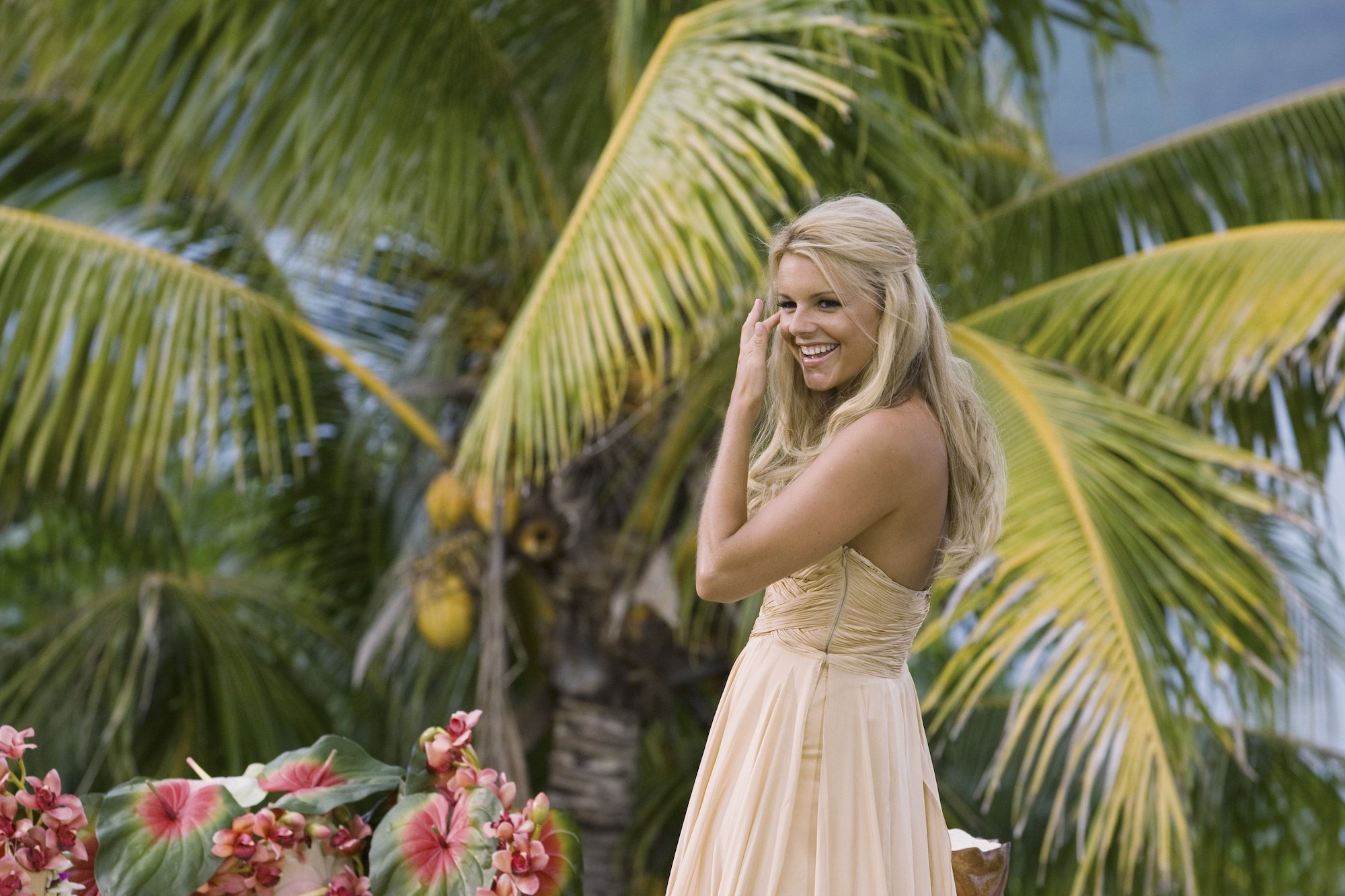 Ali Fedotowsky laughing in front of a palm tree
