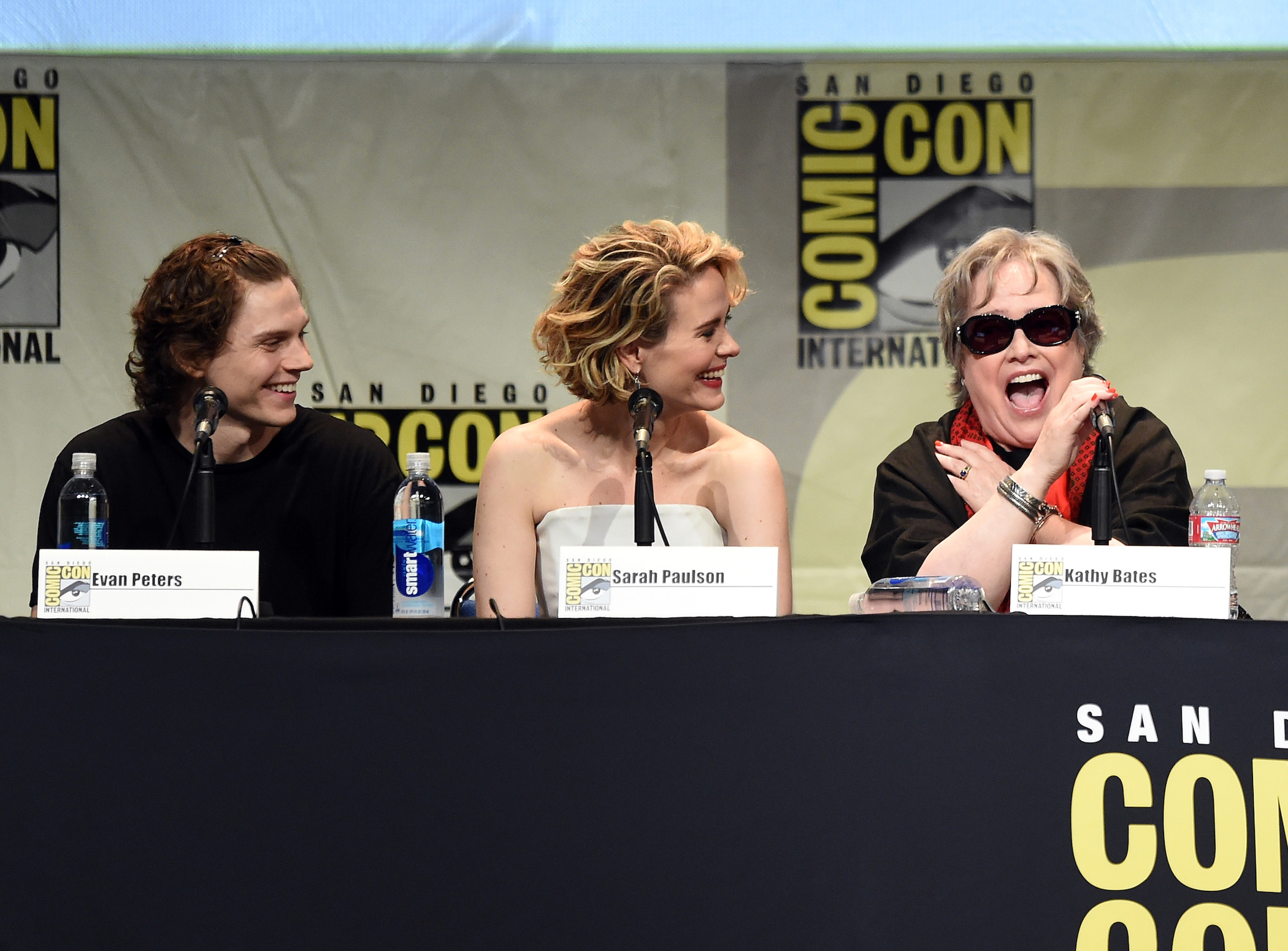 Evan Peters, Sarah Paulson, and Kathy Bates from 'American Horror Story' Season 10 sitting next to each other at a Comic Con panel in 2015