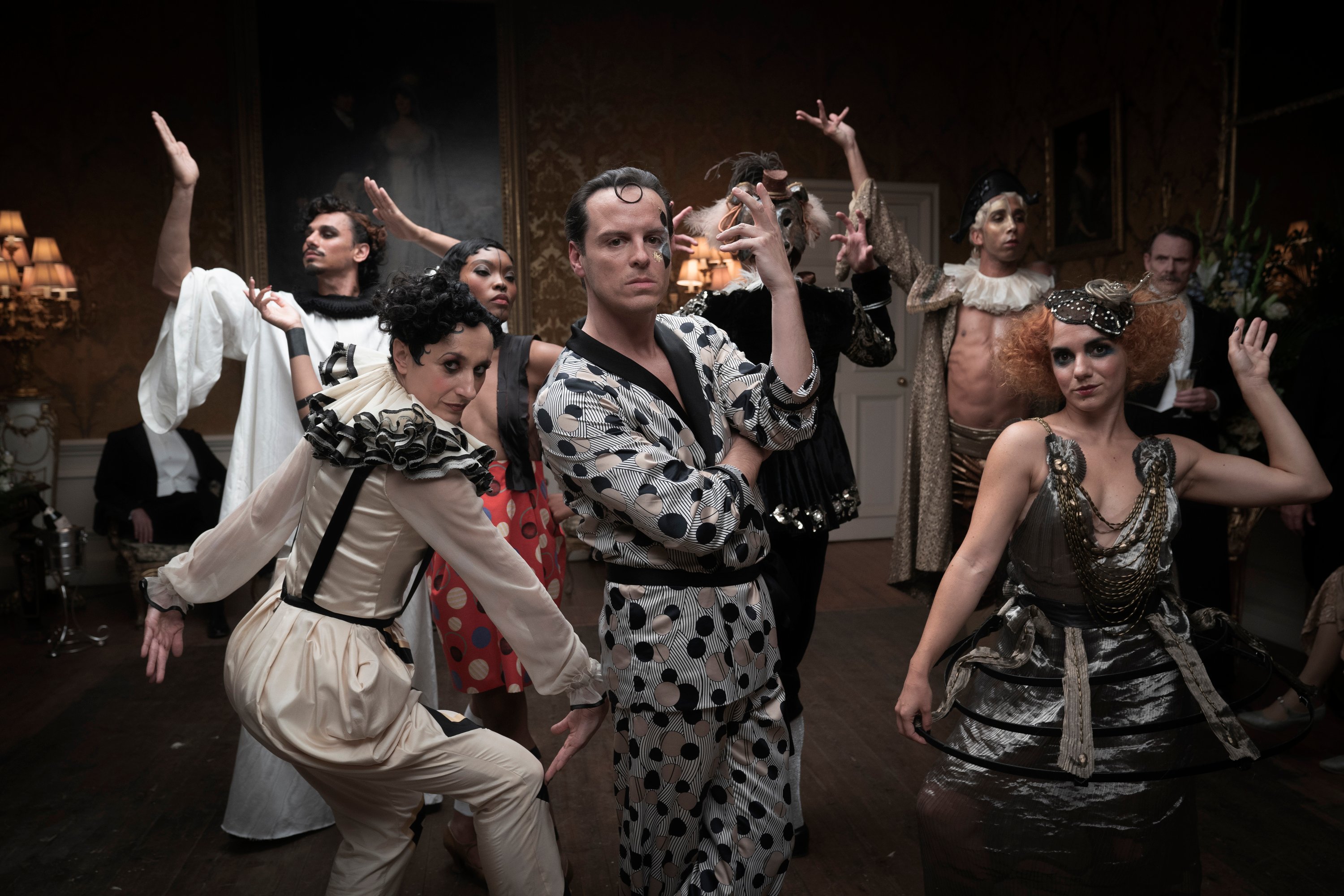 Andrew Scott as Lord Merlin, dancing and surrounded by people in costume in 'The Pursuit of Love'