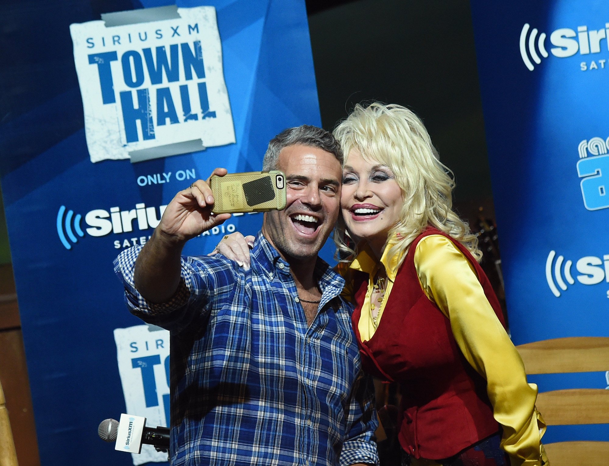 Andy Cohen and Dolly Parton posing for a photo during SiriusXM's Town Hall Series