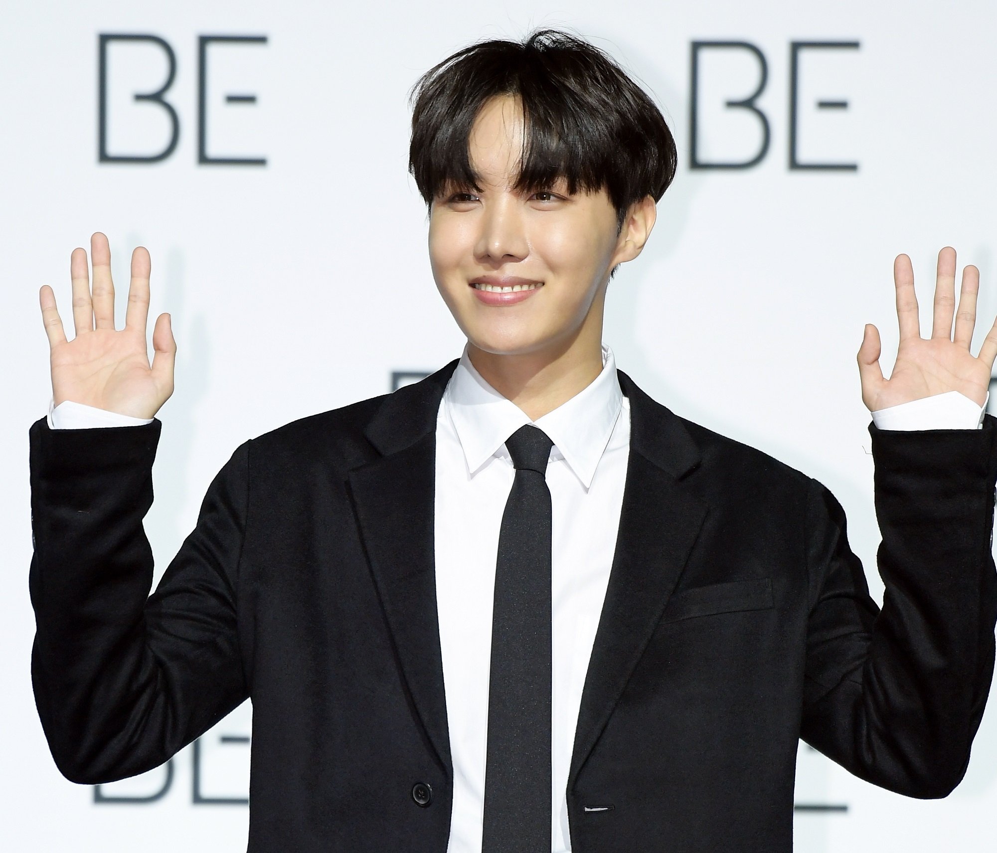 J-Hope of BTS holds up his hands at BTS' press conference for their album 'BE'