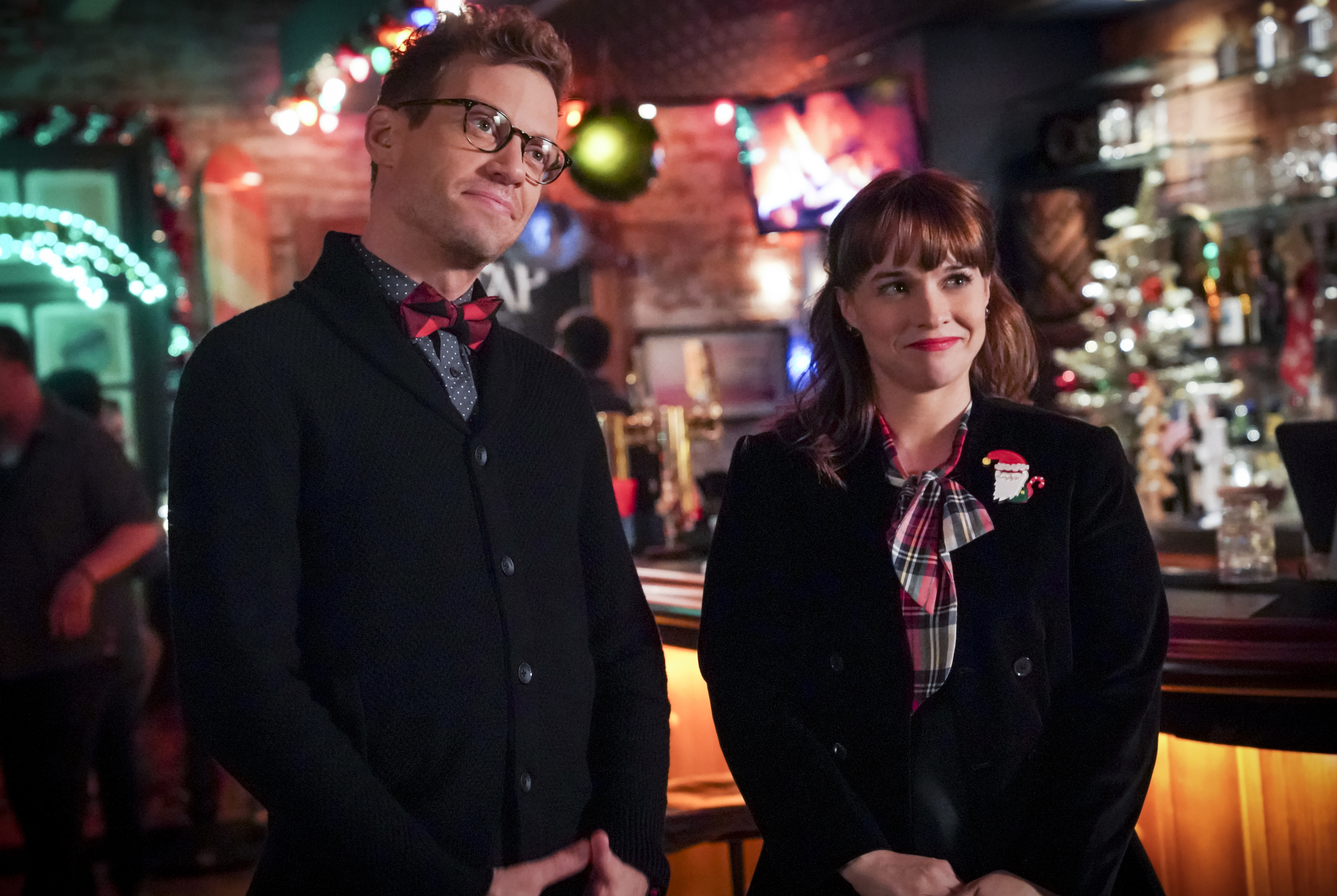 Barrett Foa and Renee Felice Smith smiling during a Christmas scene on 'NCIS: Los Angeles'