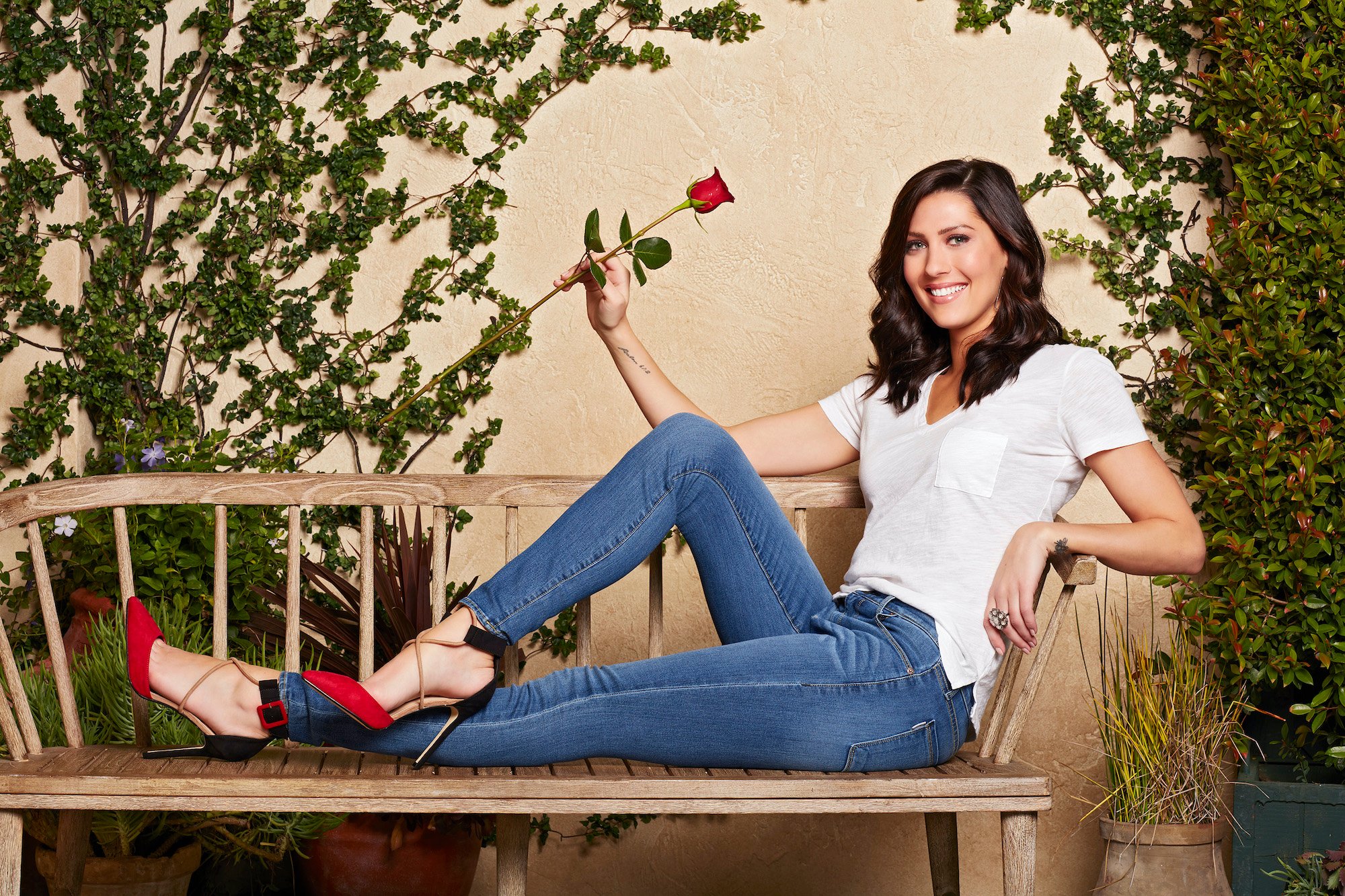 Becca Kufrin smiling, holding a rose