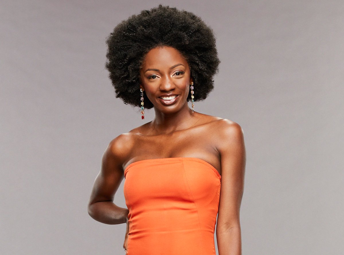 Azah Awasum of 'Big Brother 23' poses in an orange dress smiling.