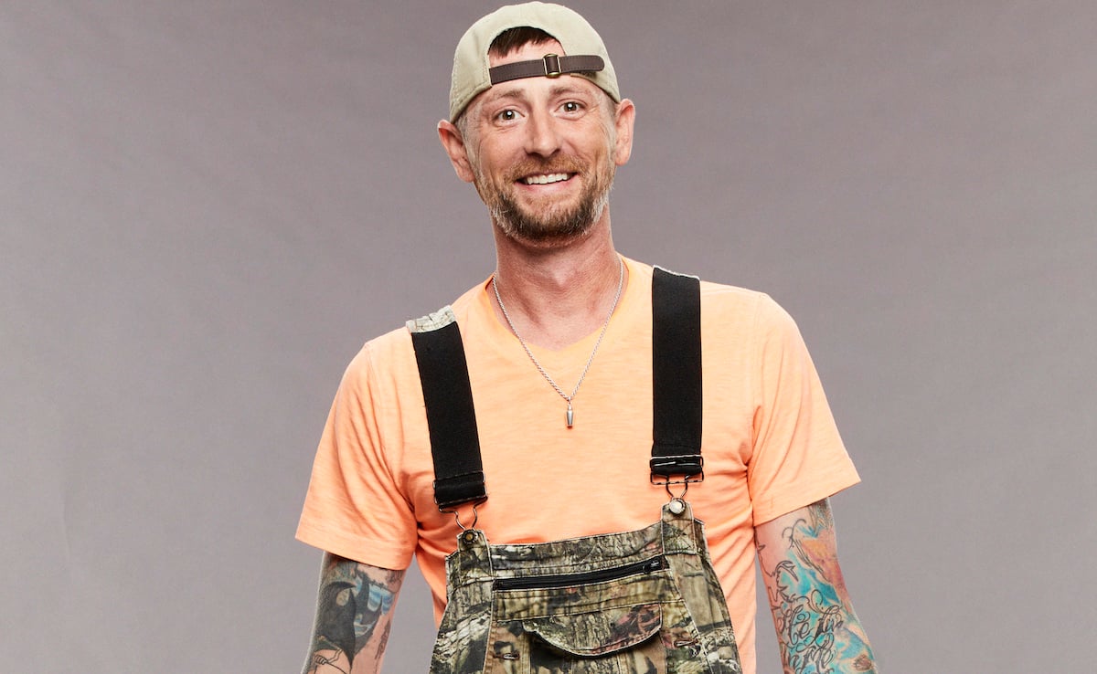 Brandon Frenchie French of 'Big Brother 23' poses in an orange shirt and camo overalls.