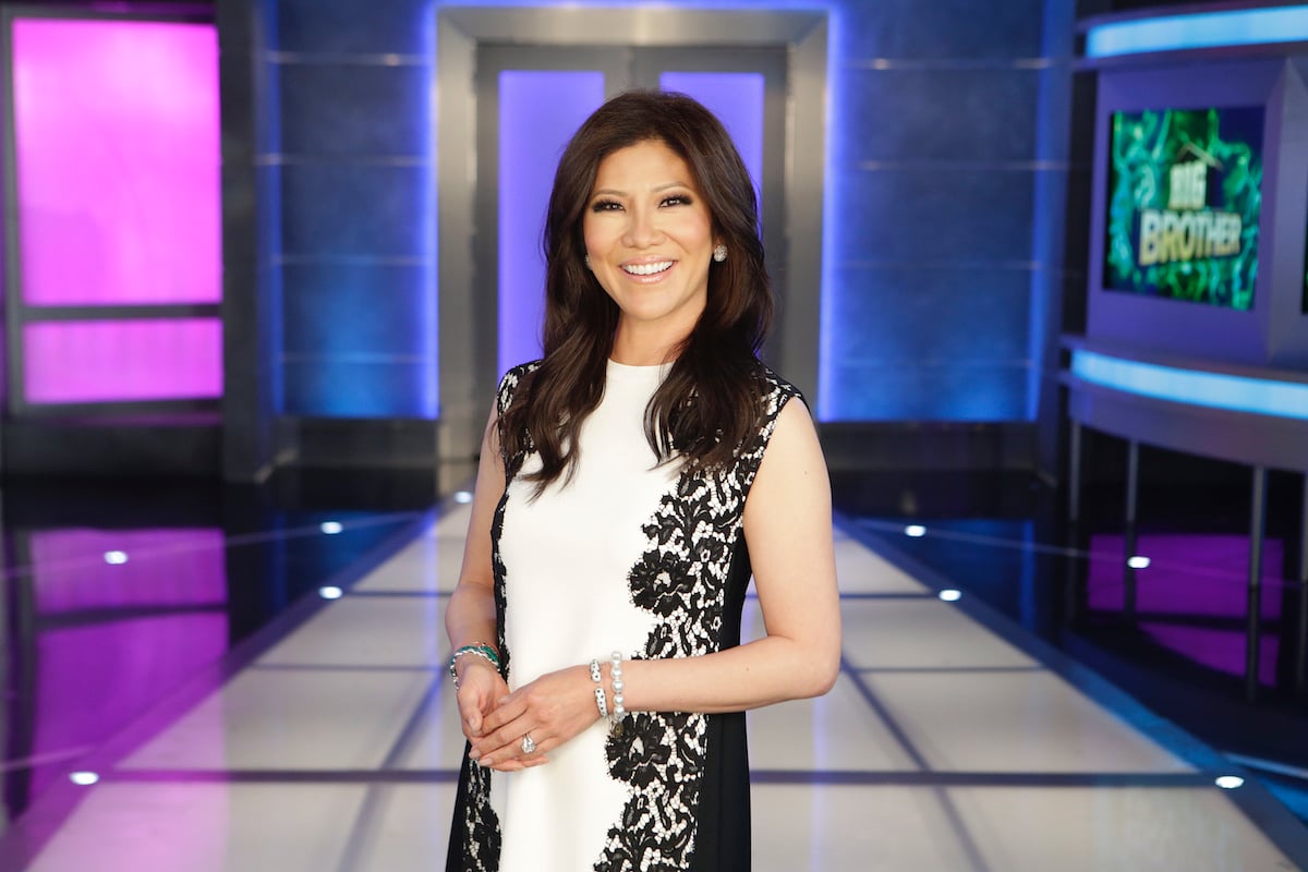 Julie Chen smiles wearing a black and white dress on the set of 'Big Brother'