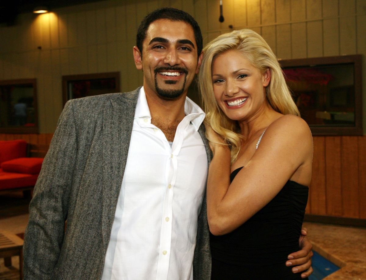 Kaysar Ridha wears a shirt and jacket and Janelle Pierzina wears a black dress as they pose together smiling of 'Big Brother'