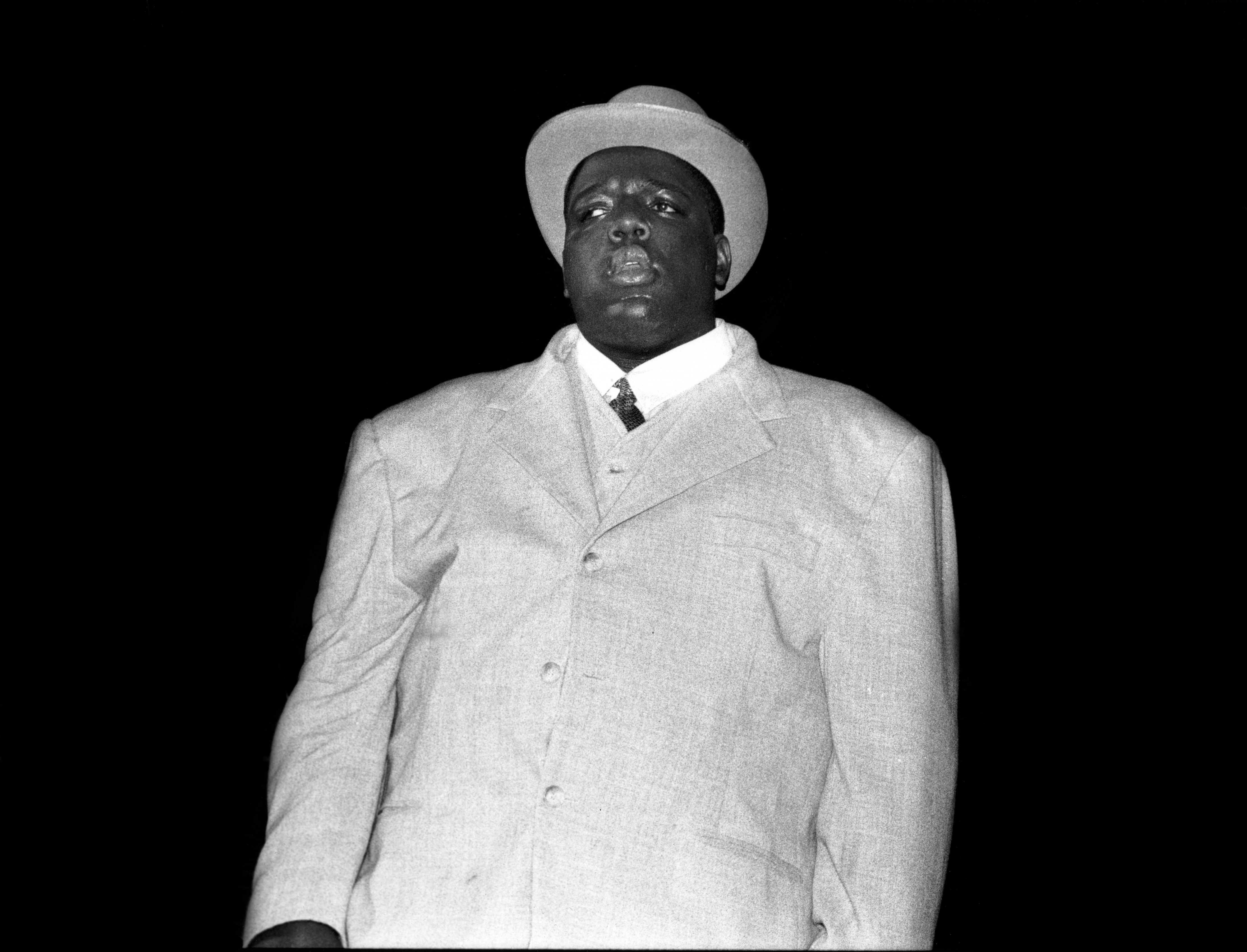 The Notorious B.I.G. wearing a suit and hat