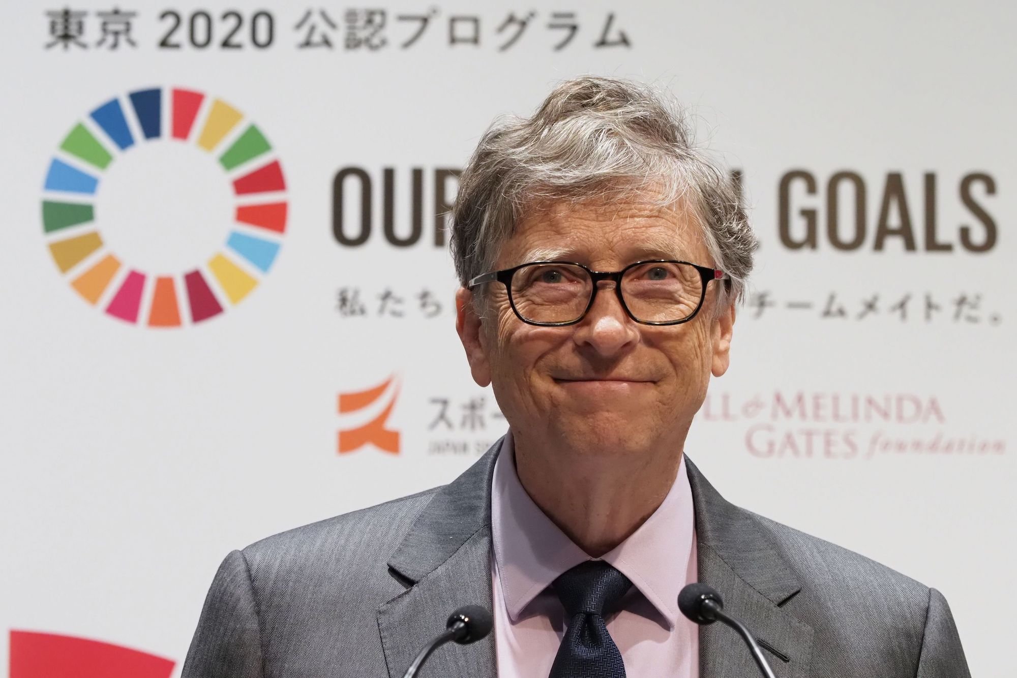 Bill Gates in front of a white and multi color background
