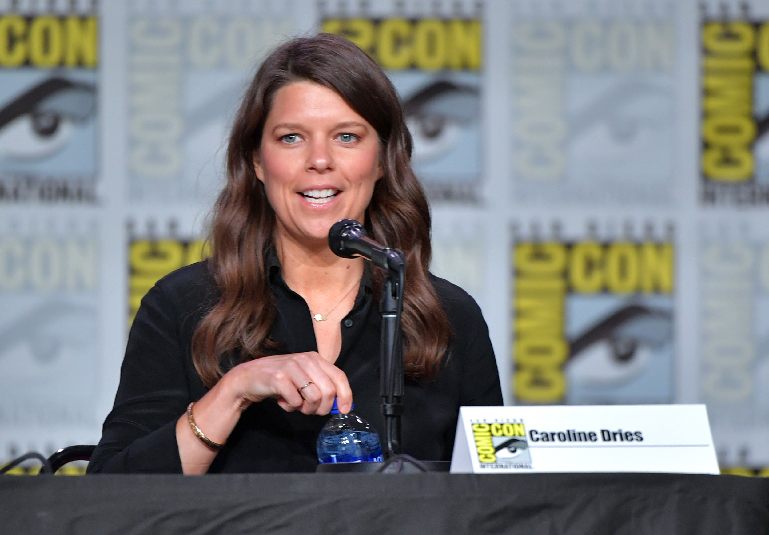 Caroline Dries wearing a black shirt and sitting on a panel at San Diego Comic-Con