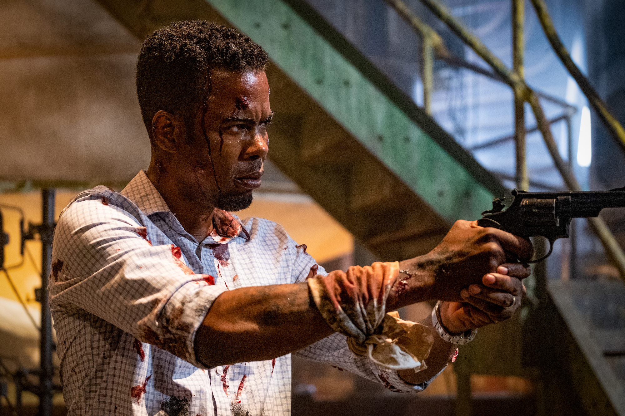 Chris Rock holds a gun in Spiral