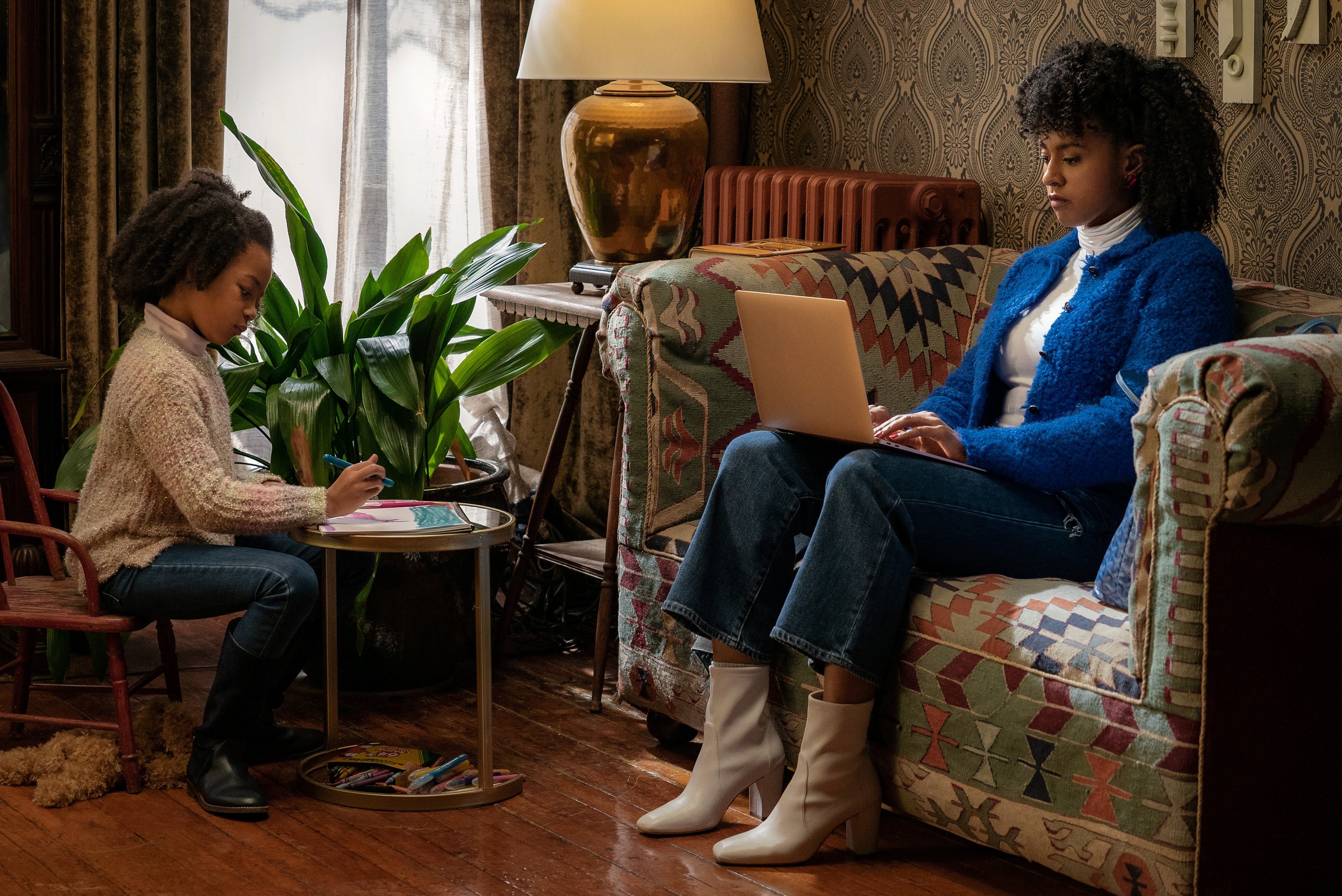 Corbin Reid works at her computer while Ellie Reine plays