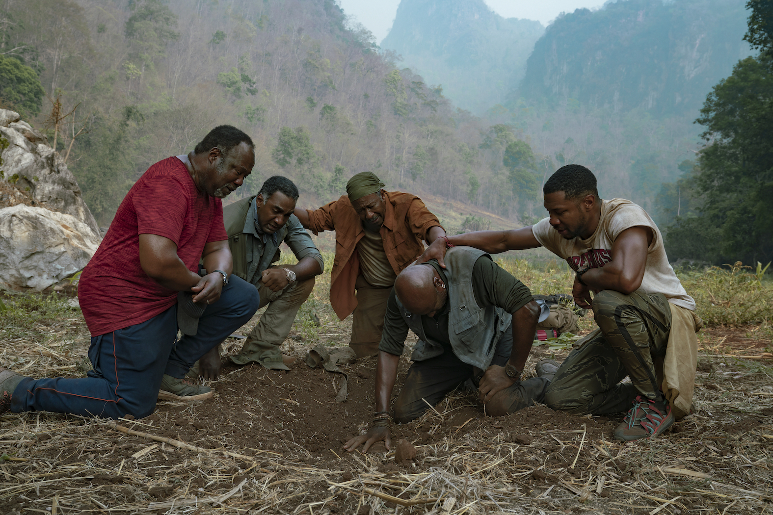 Five actors kneeling on the ground in a circle in 'Da 5 Bloods,' one of the best war movies on Netflix