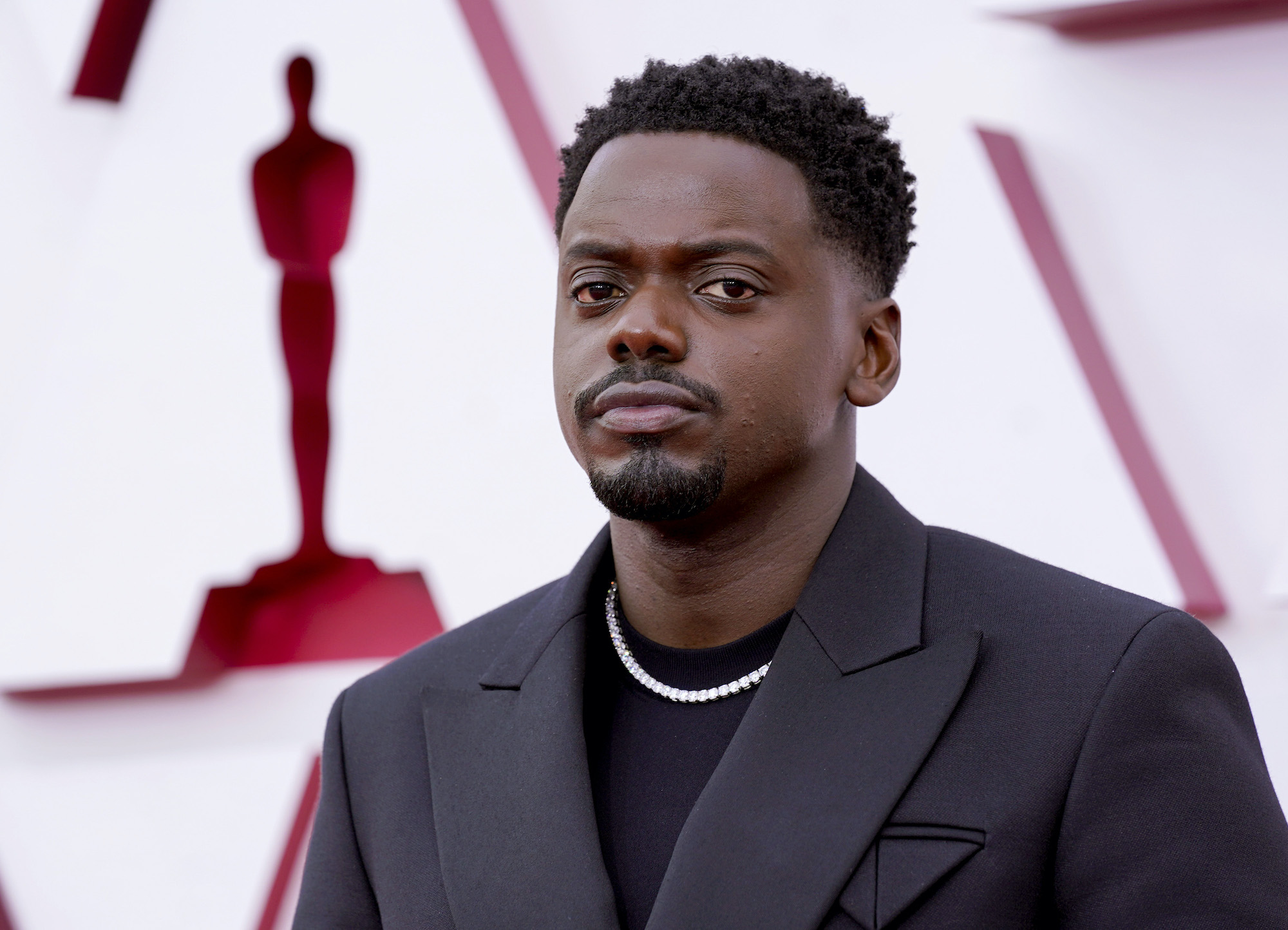 Daniel Kaluuya standing in front of a blurred background