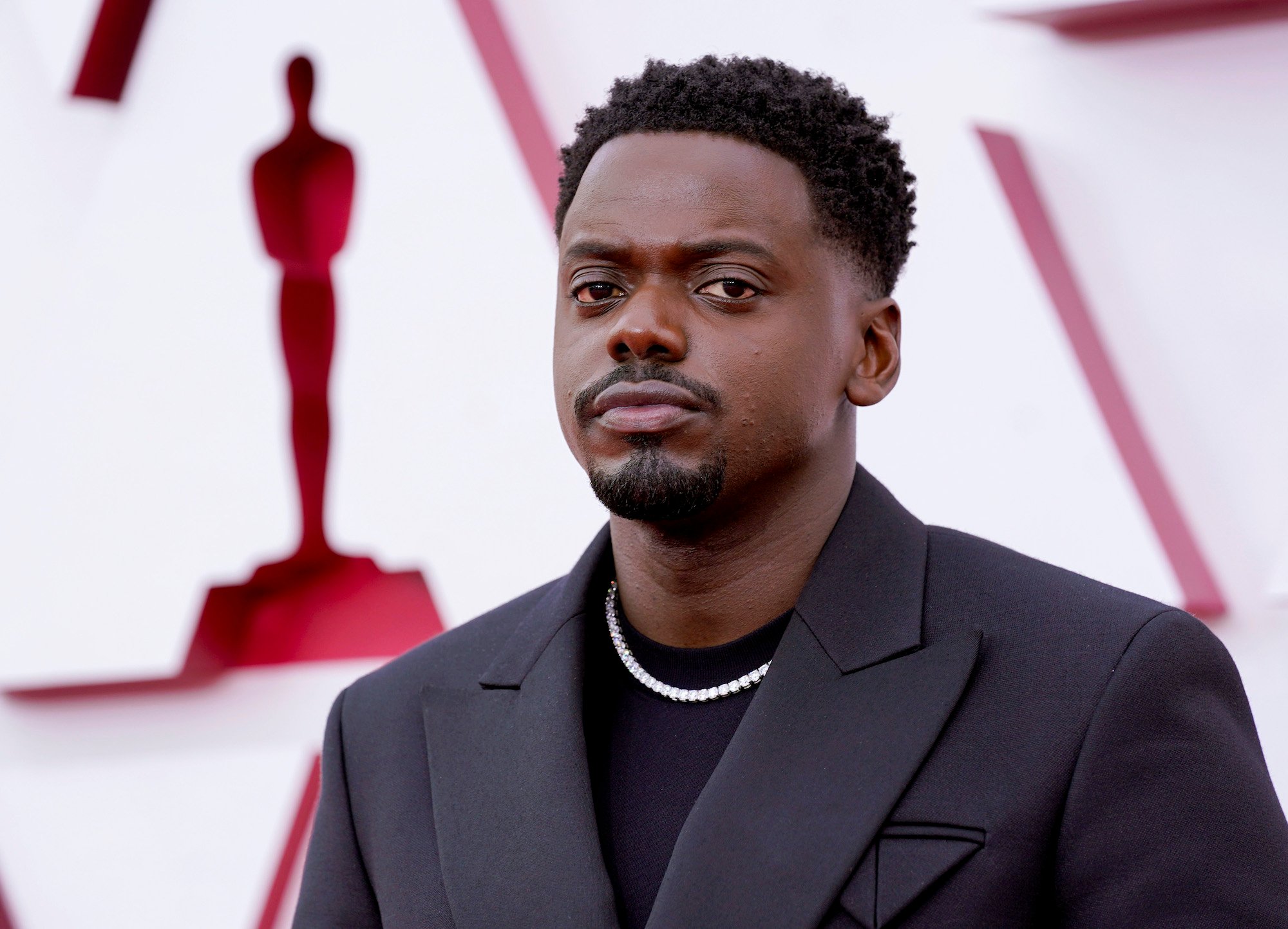 Daniel Kaluuya standing in front of a blurred background