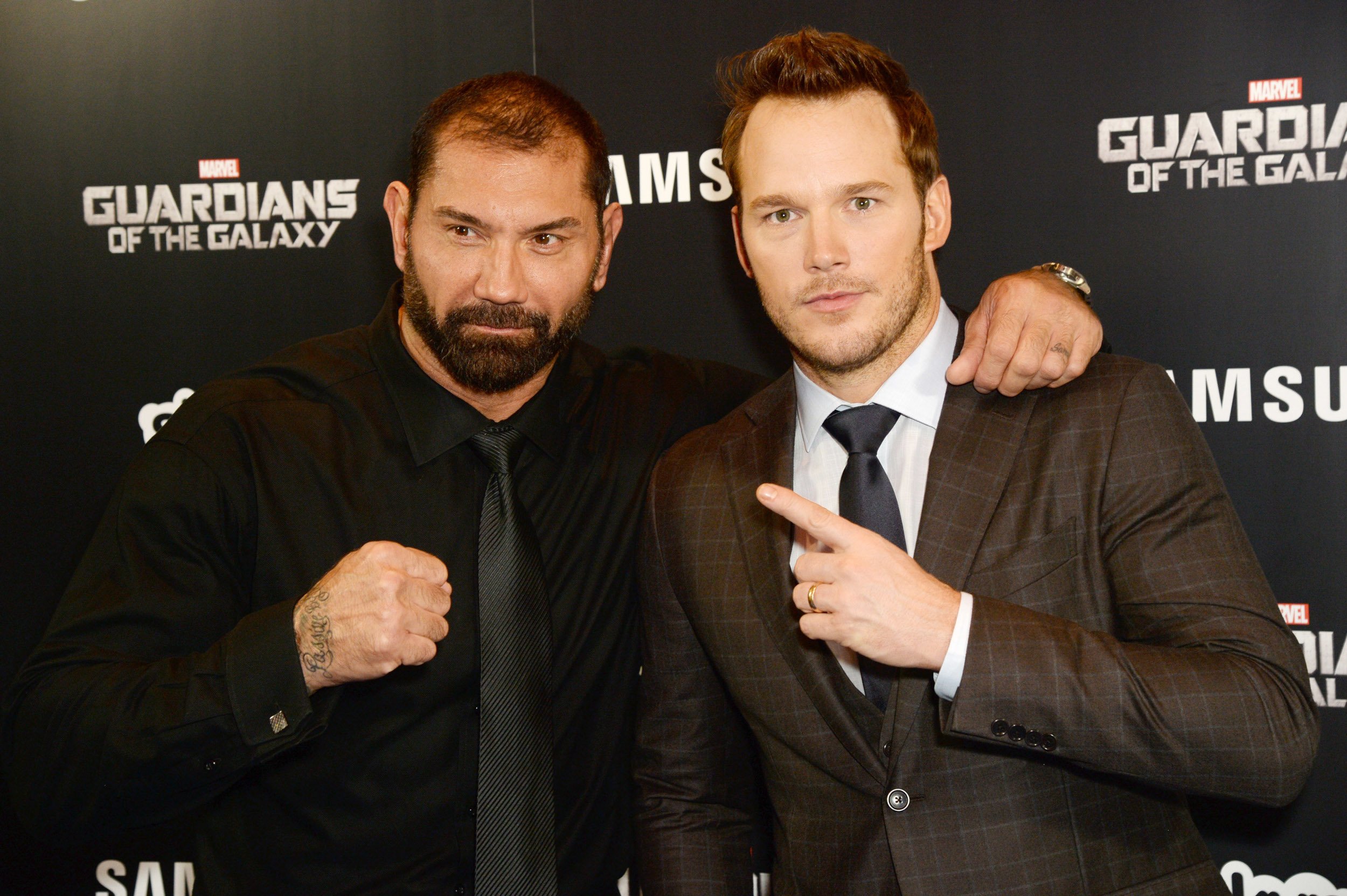 Dave Bautista and Chris Pratt stand in front of 'Guardians of the Galaxy' wall