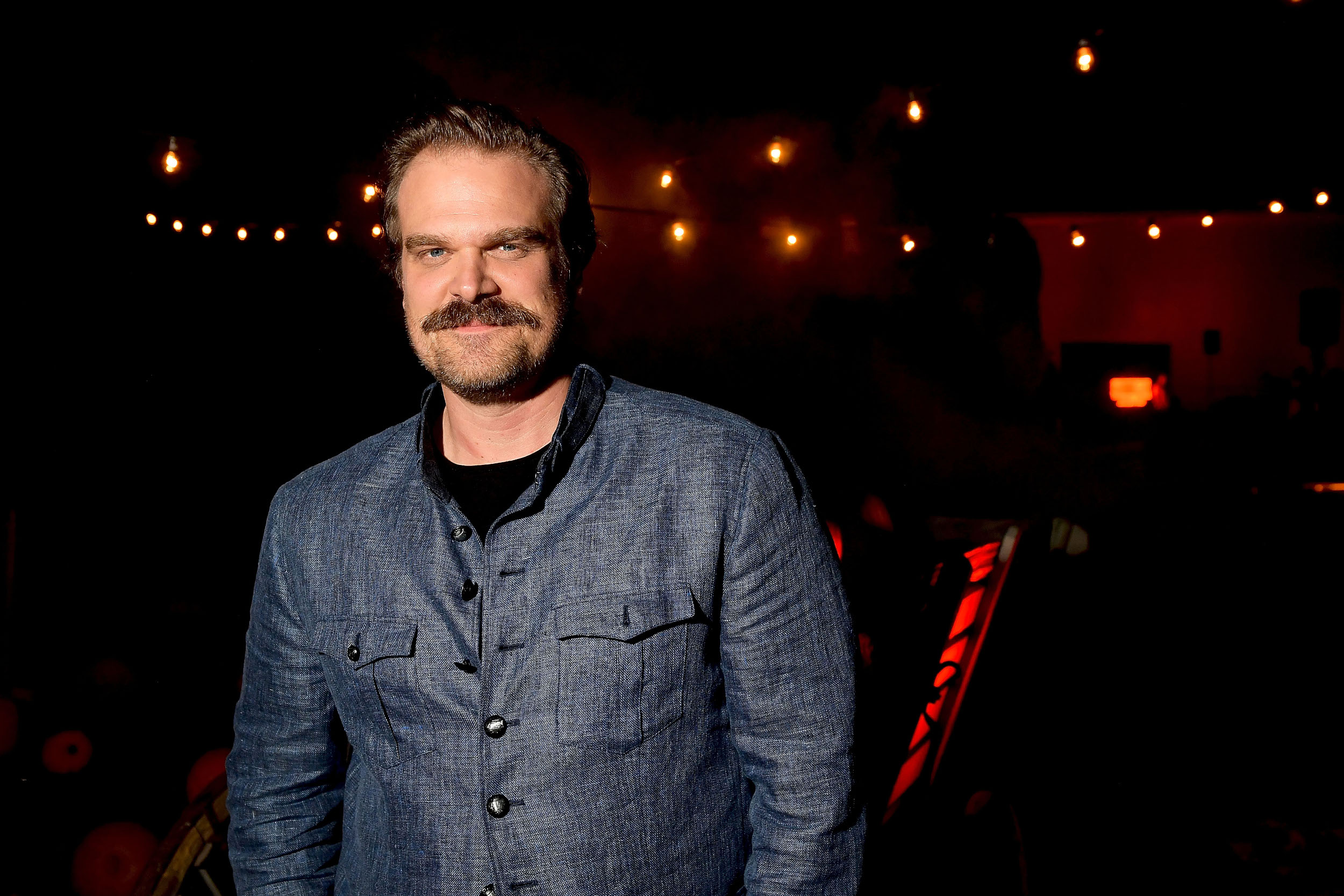 'Black Widow' star David Harbour wears a blue shirt and smiles