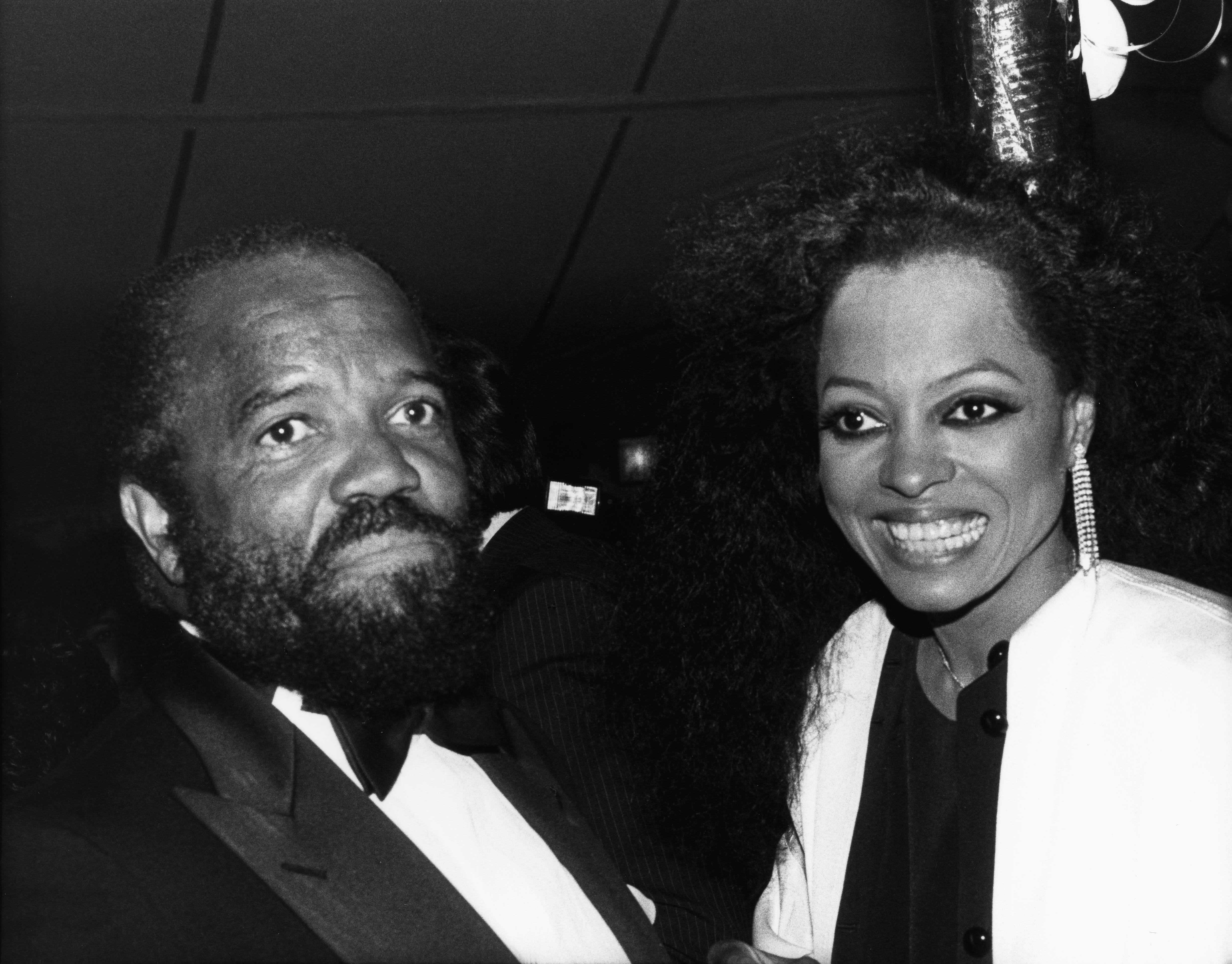 Diana Ross and Berry Gordy smiling in a black-and-white photo at an event.