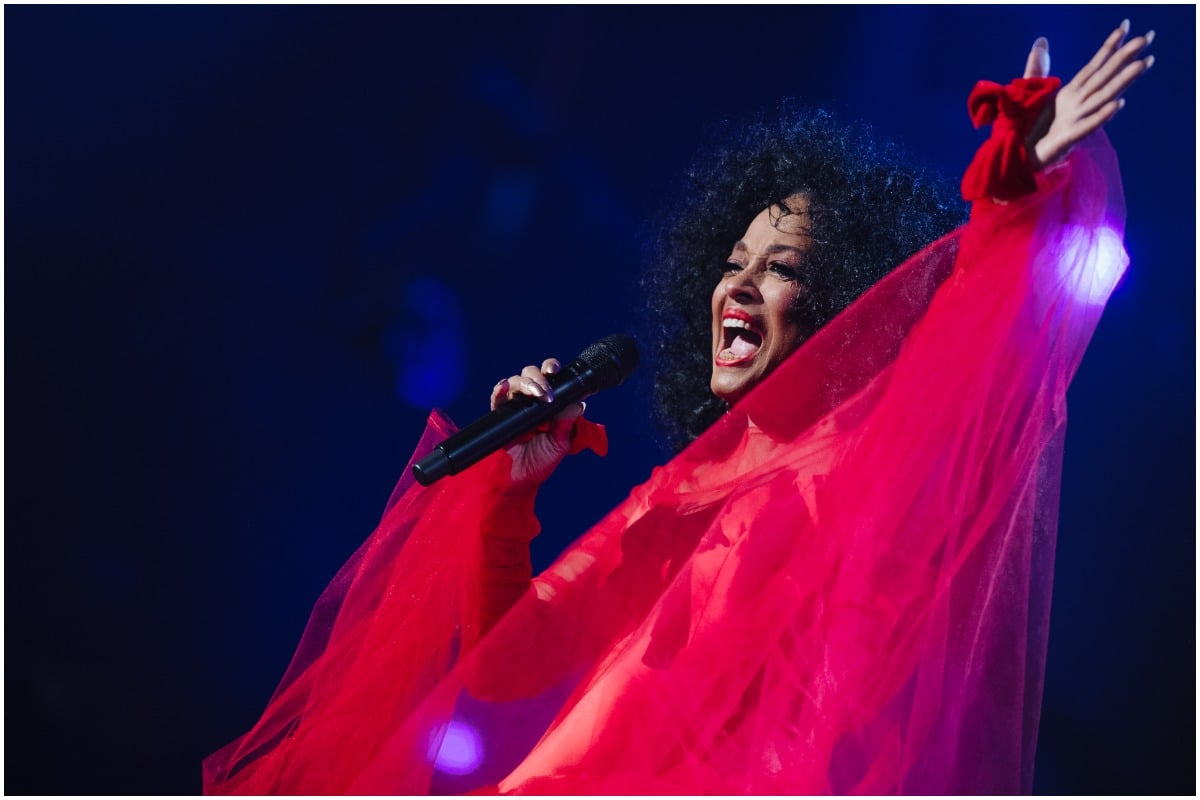 Diana Ross performing onstage while wearing a red dress.