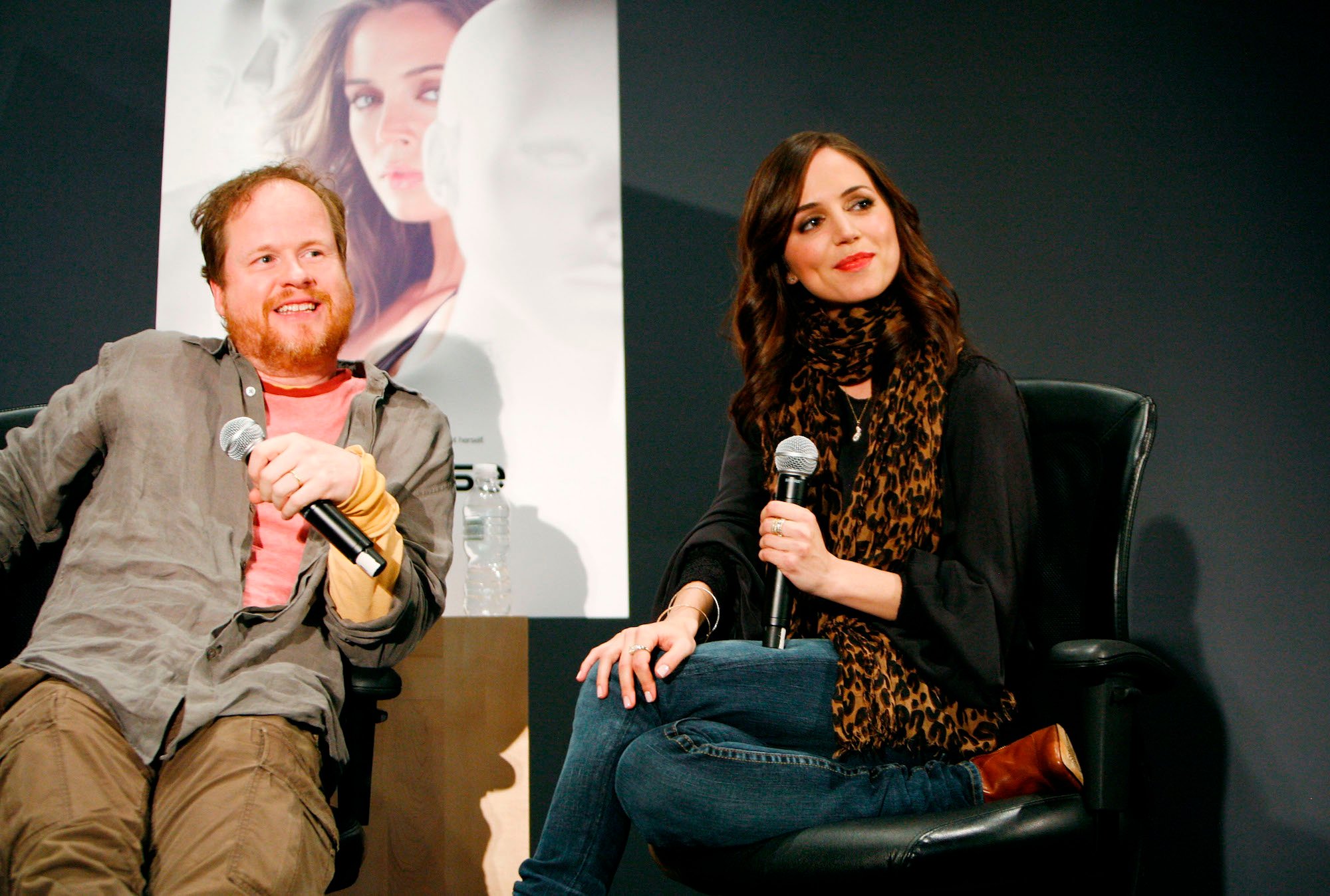 Joss Whedon and Eliza Dushku seated, holding microphones