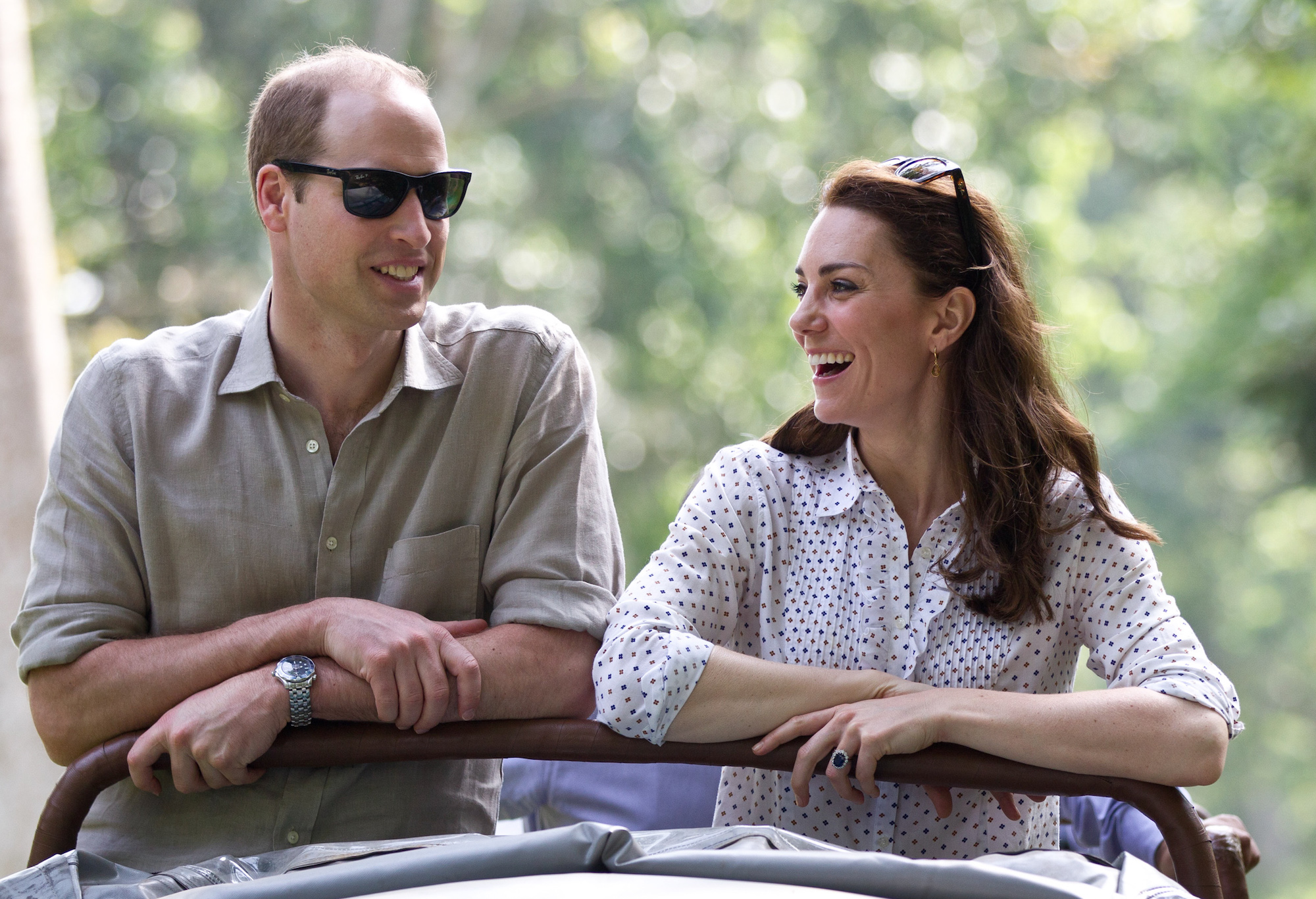 Prince William and Kate Middleton laughing in front of a blurred background in this royals picture