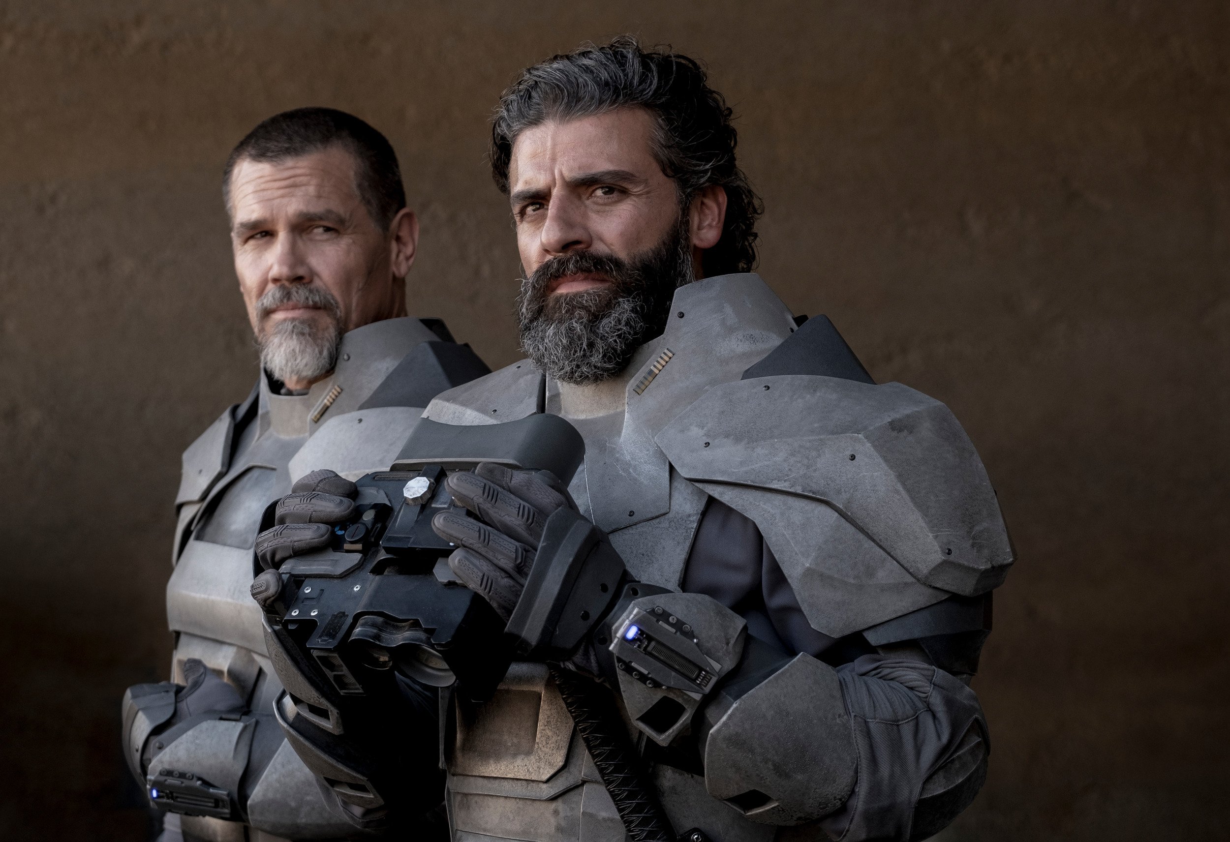 Oscar Isaac as Duke Atreides in the Dune trailer. He's standing with Josh Brolin as Gurney and holding binoculars