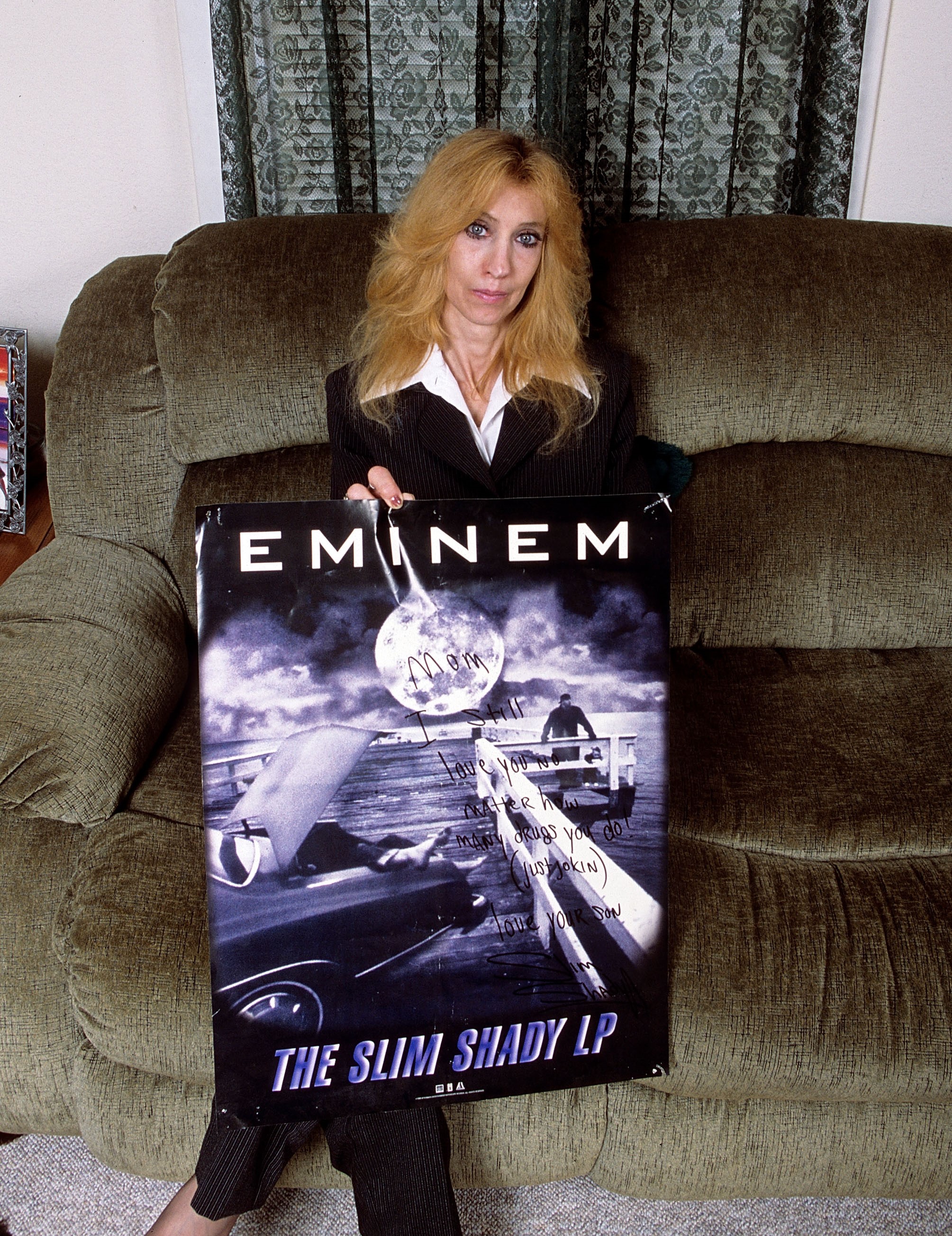Eminem's mother Debbie Mathers holds a poster with a hand written message during a portrait session at her home