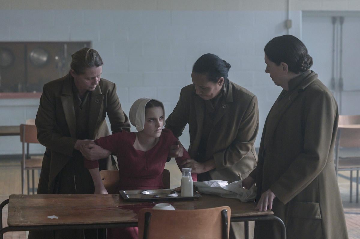 Mckenna Grace as Esther Keyes and Ann Dowd as Aunt Lydia in 'The Handmaid's Tale' Season 4. Grace's arms are held back by other Aunts as Aunt Lydia (Dowd) looks at her sternly.