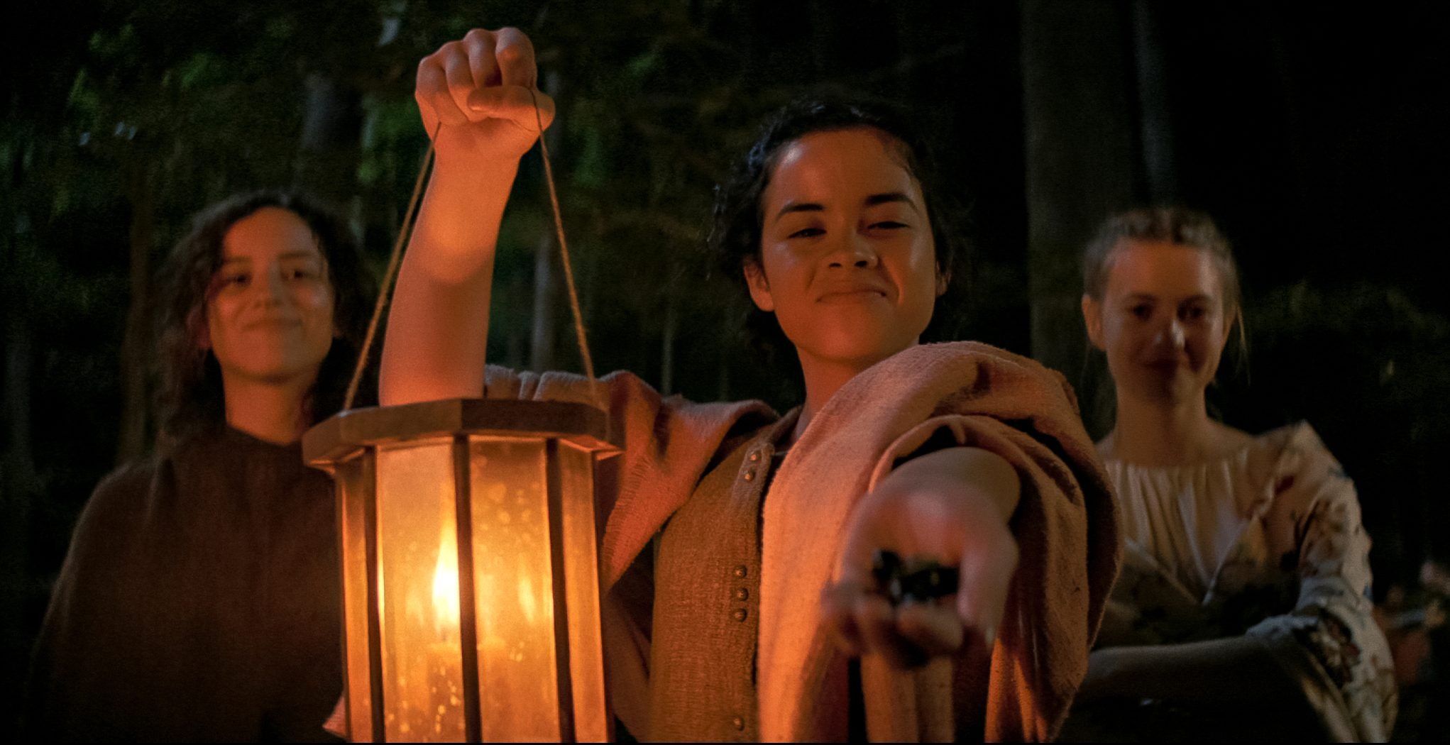 Kiana Madeira, Julia Rehwald, and Olivia Scott Welch sharing berries in 'Fear Street Part 3: 1666'