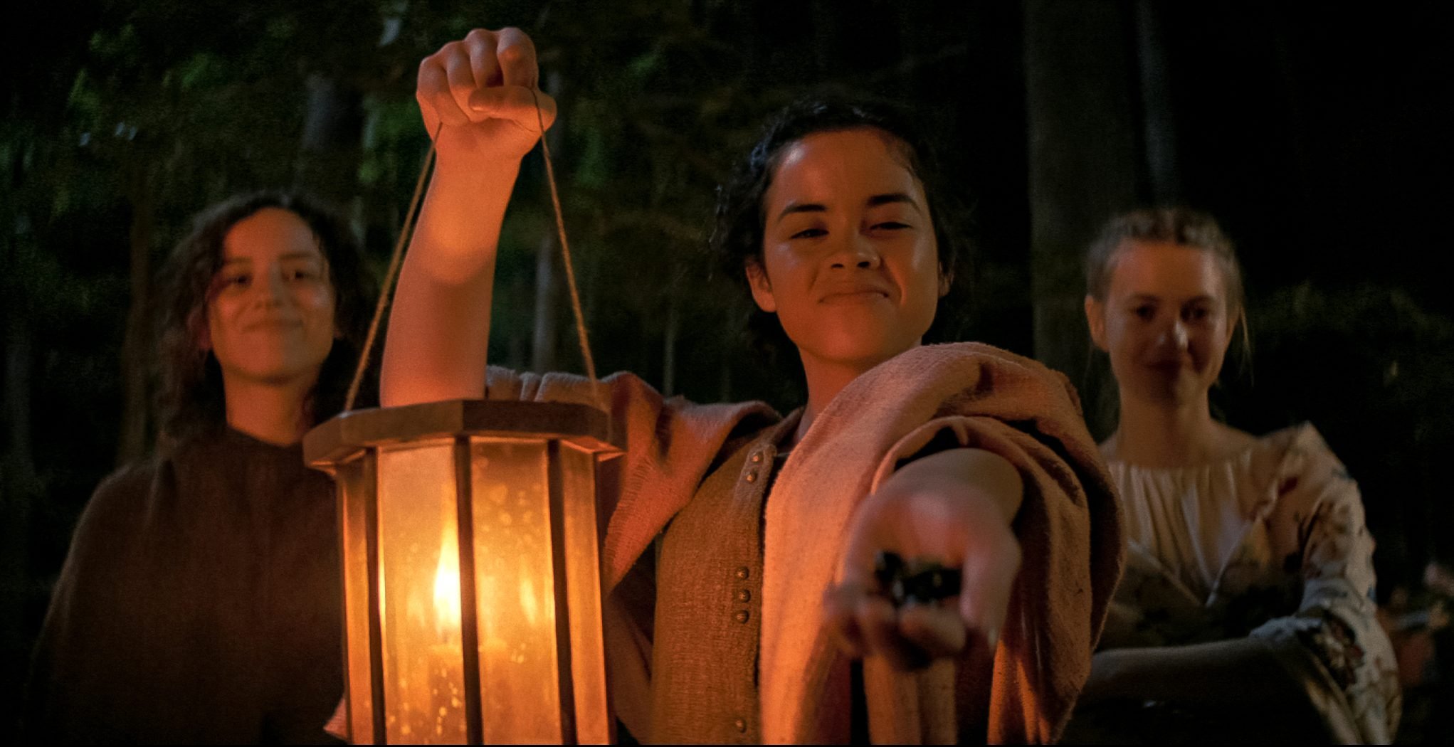 Kiana Madeira, Julia Rehwald, and Olivia Scott Welch sharing berries in 'Fear Street Part 3: 1666'