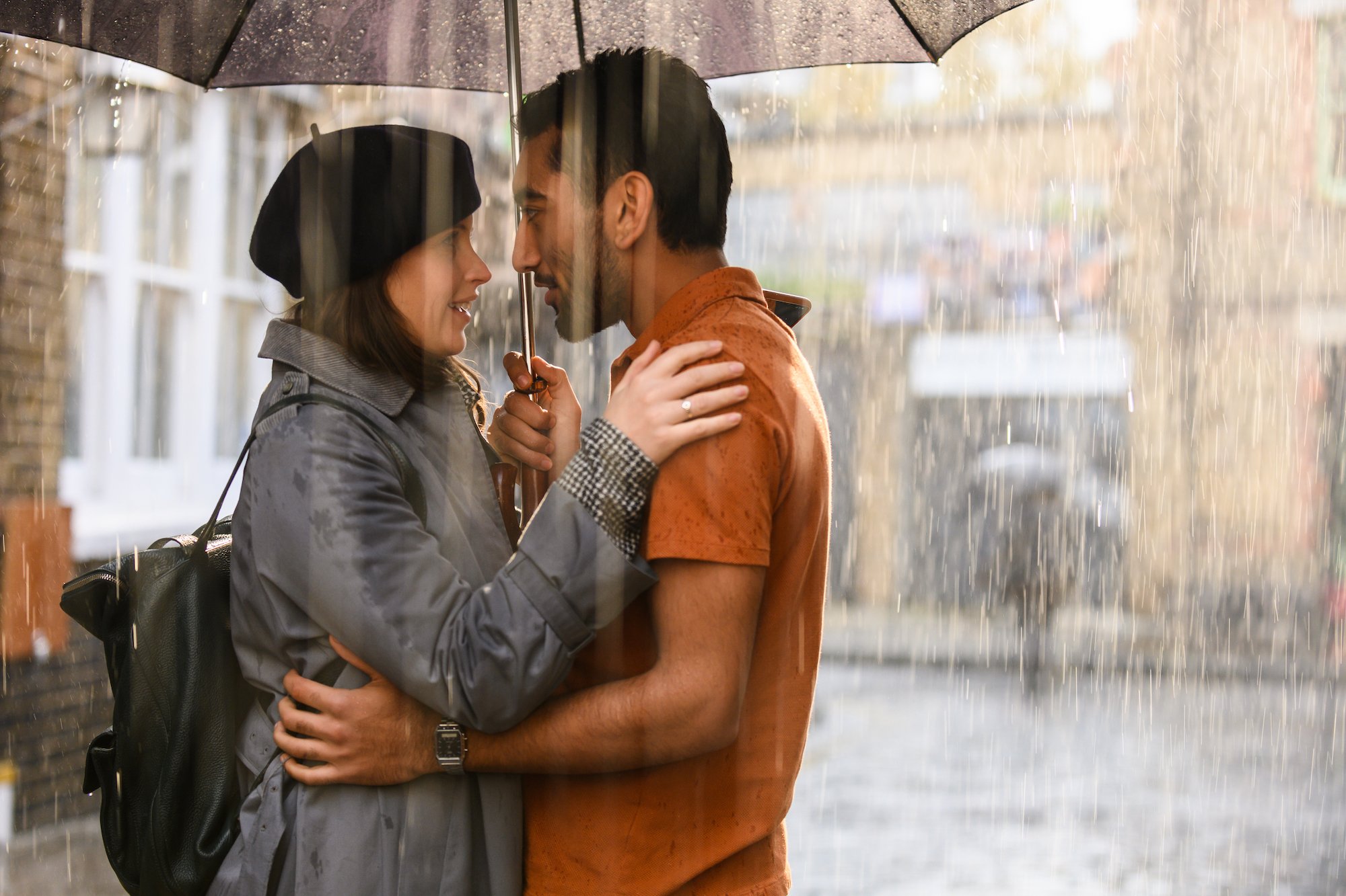 Felicity Jones and Nabhaan Rizwan stand under an umbrella in the rain
