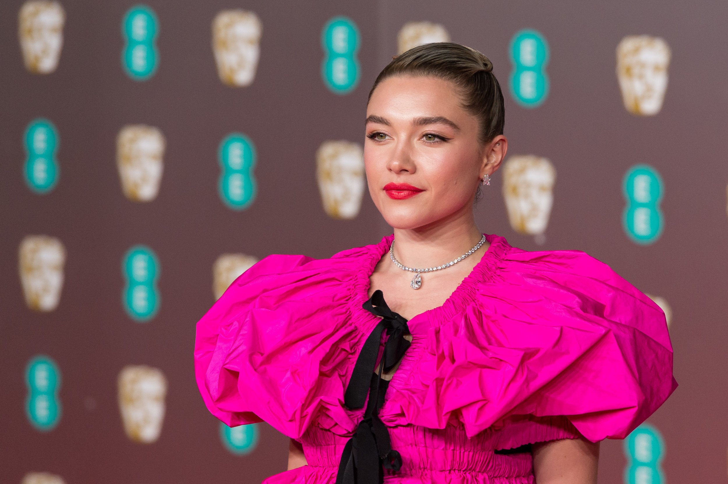 Florence Pugh wearing a pink ruffled dress with her hair tied back