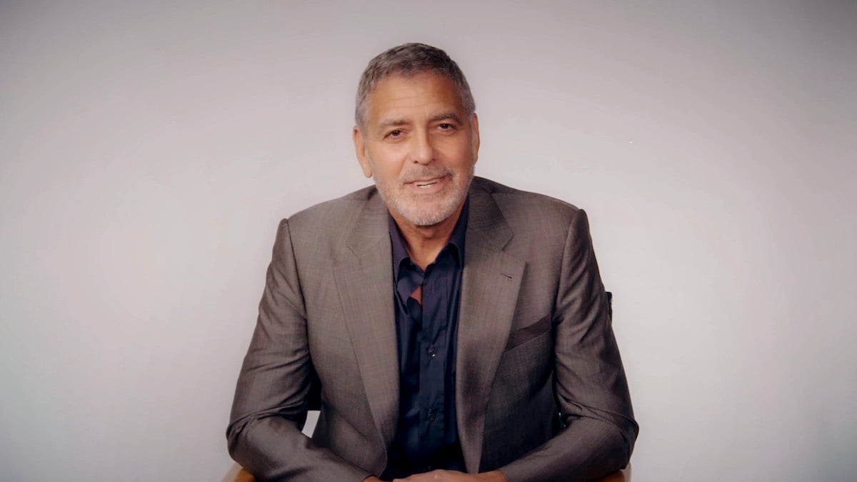 George Clooney sitting in a chair