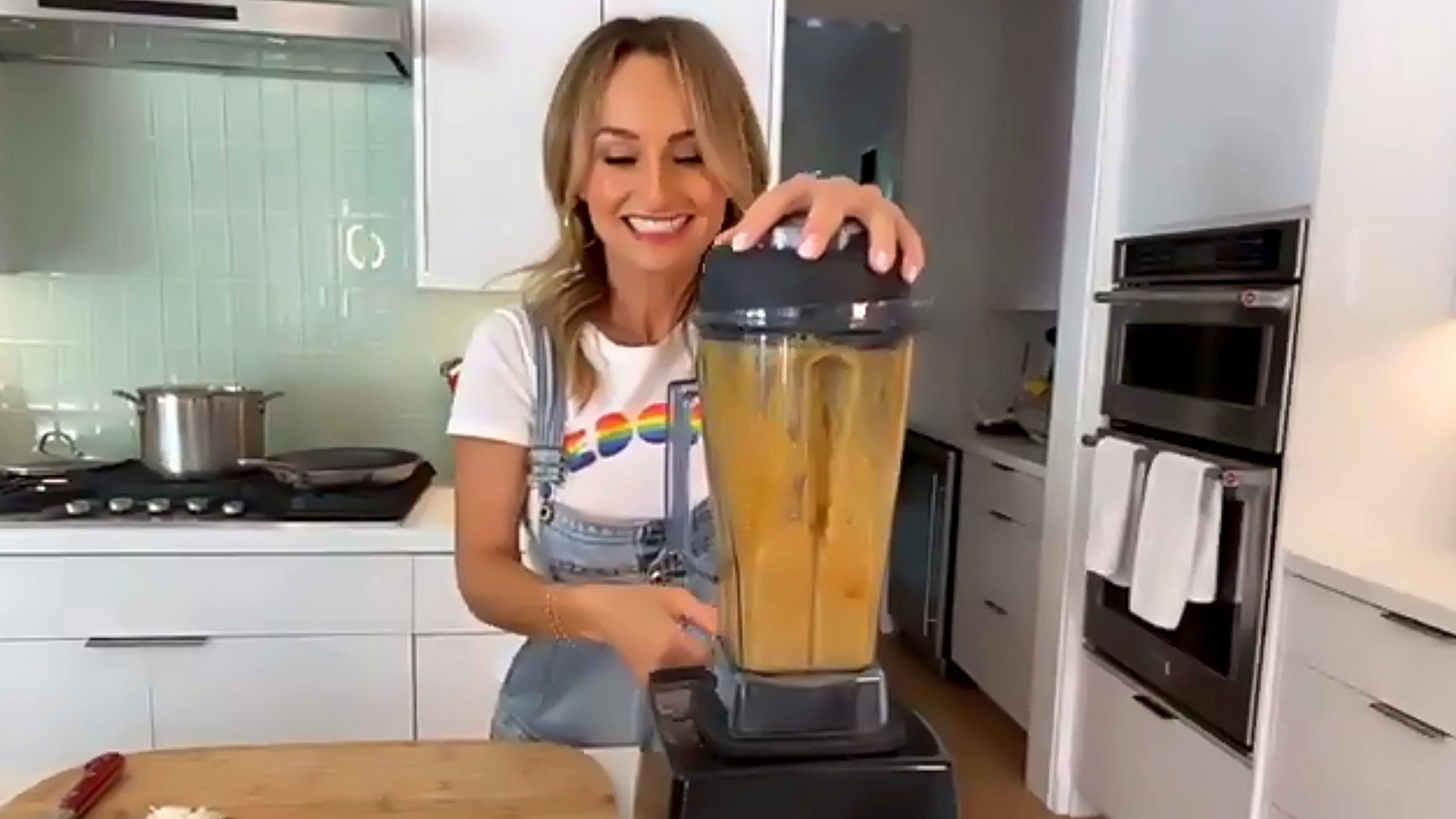 Food Network personality Giada De Laurentiis prepares a recipe with a blender. In the photo she wears a denim jumper.